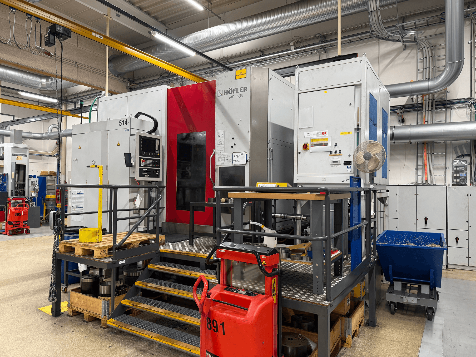 HOFLER HF 600 machine tool, side view, showing control panel, yellow safety barrier, and surrounding workshop environment.