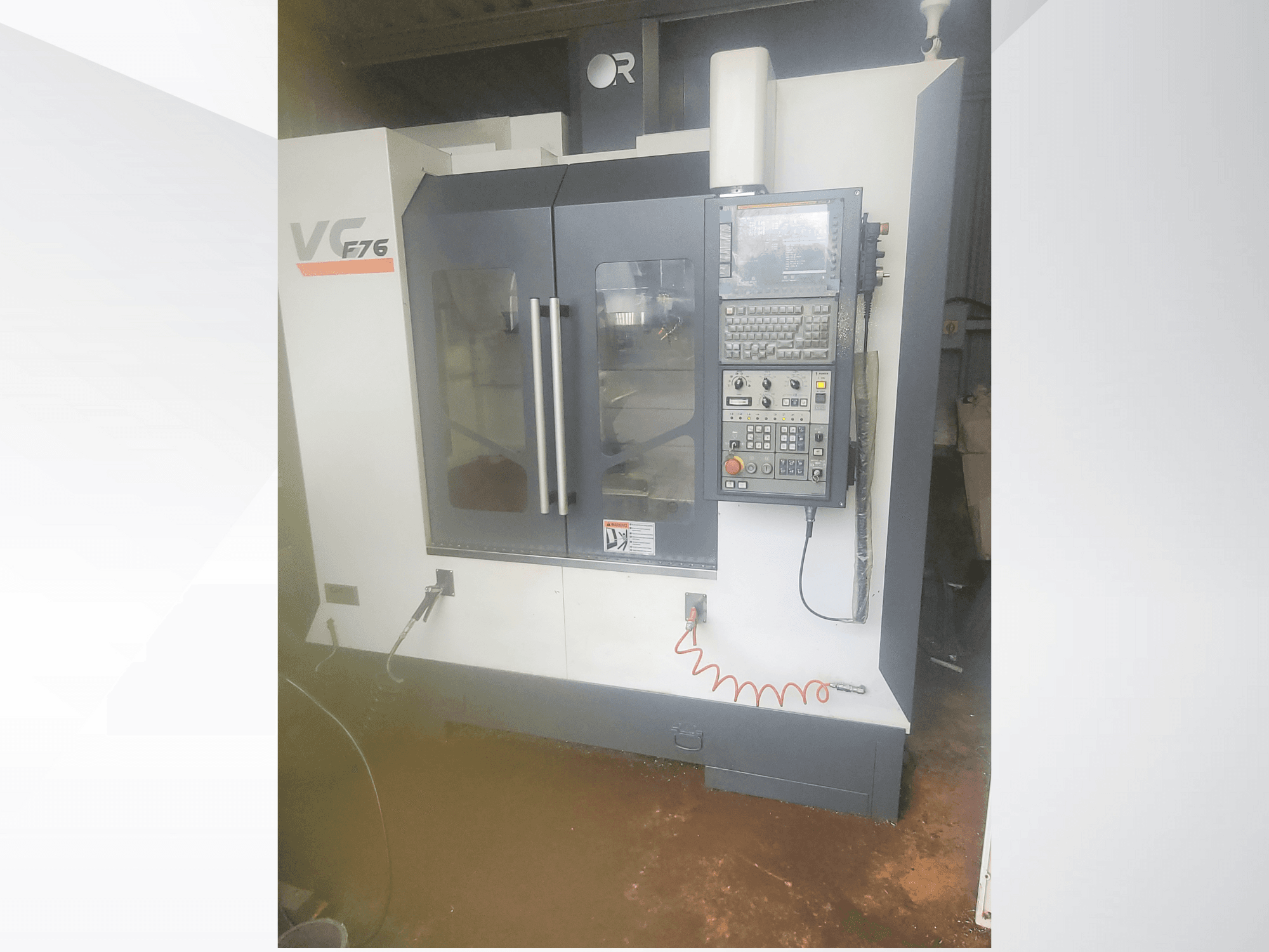 Vertical machining center, brand VC, model F76; front view showing control panel and glass doors.