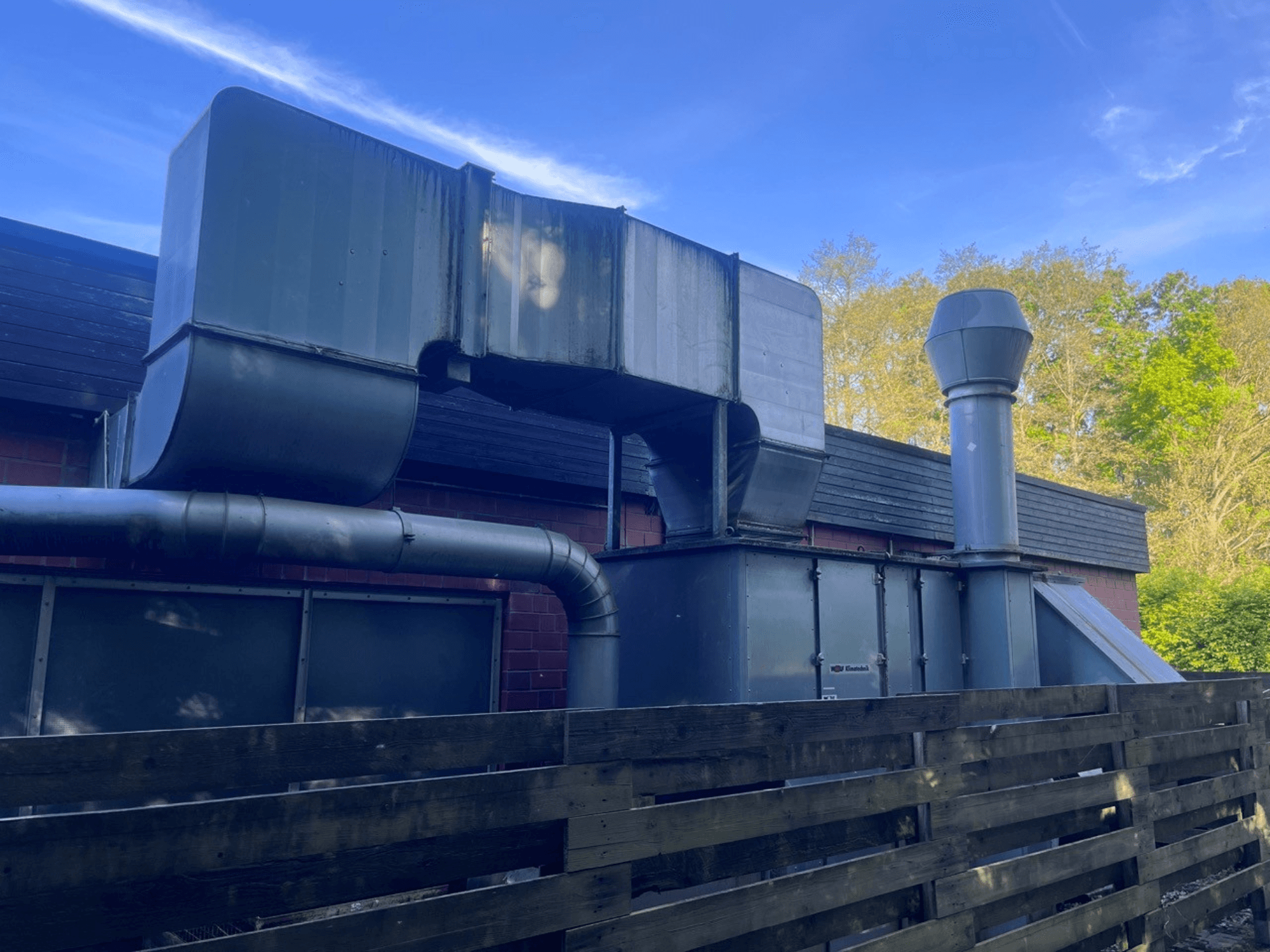 Industrial ventilation system with metallic ducts, side view; includes a square and cylindrical chimney, green finish.