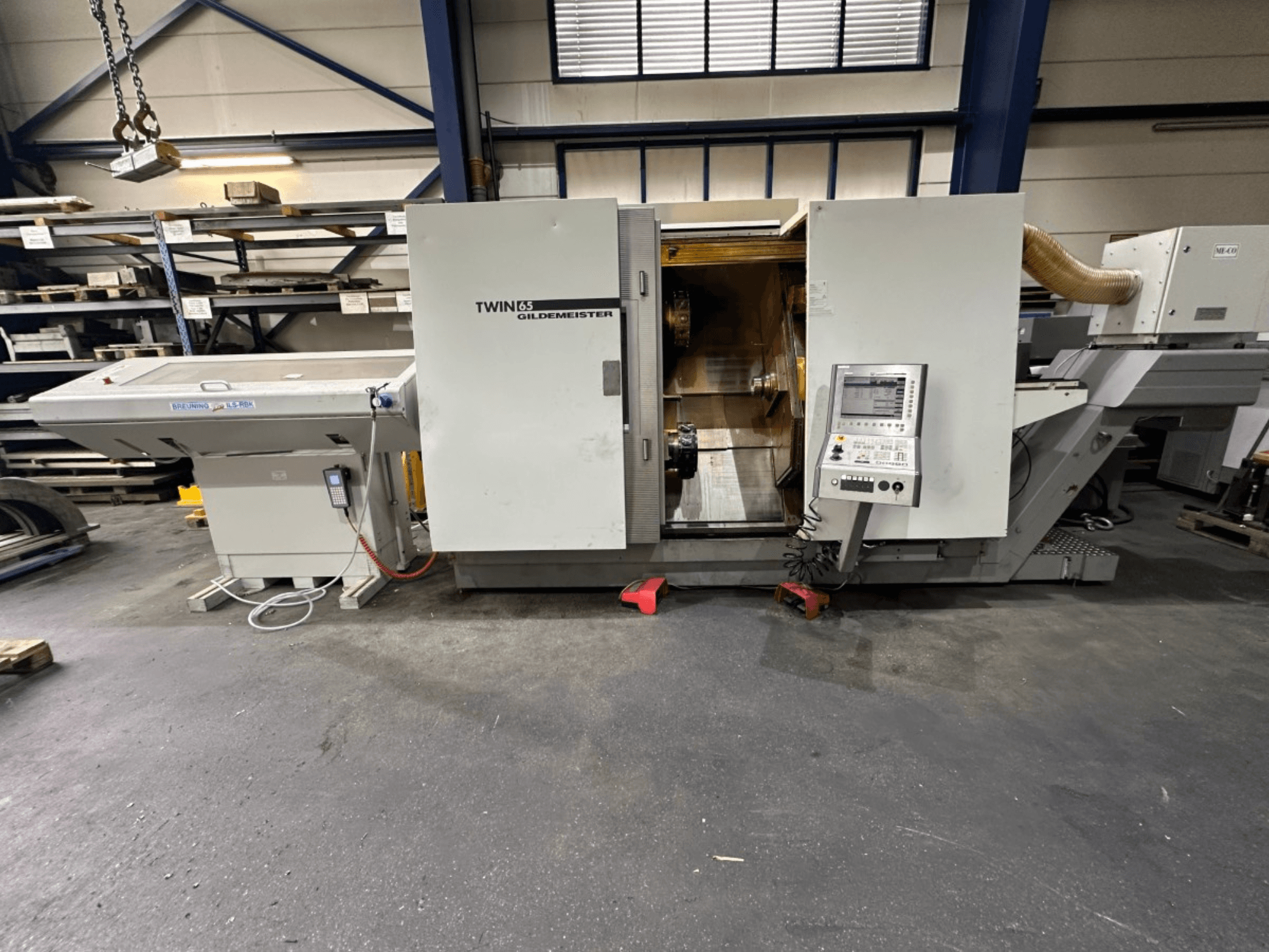 Gildemeister TWIN 65 horizontal turning machine, front view; features control panel and visible interior for machining parts.