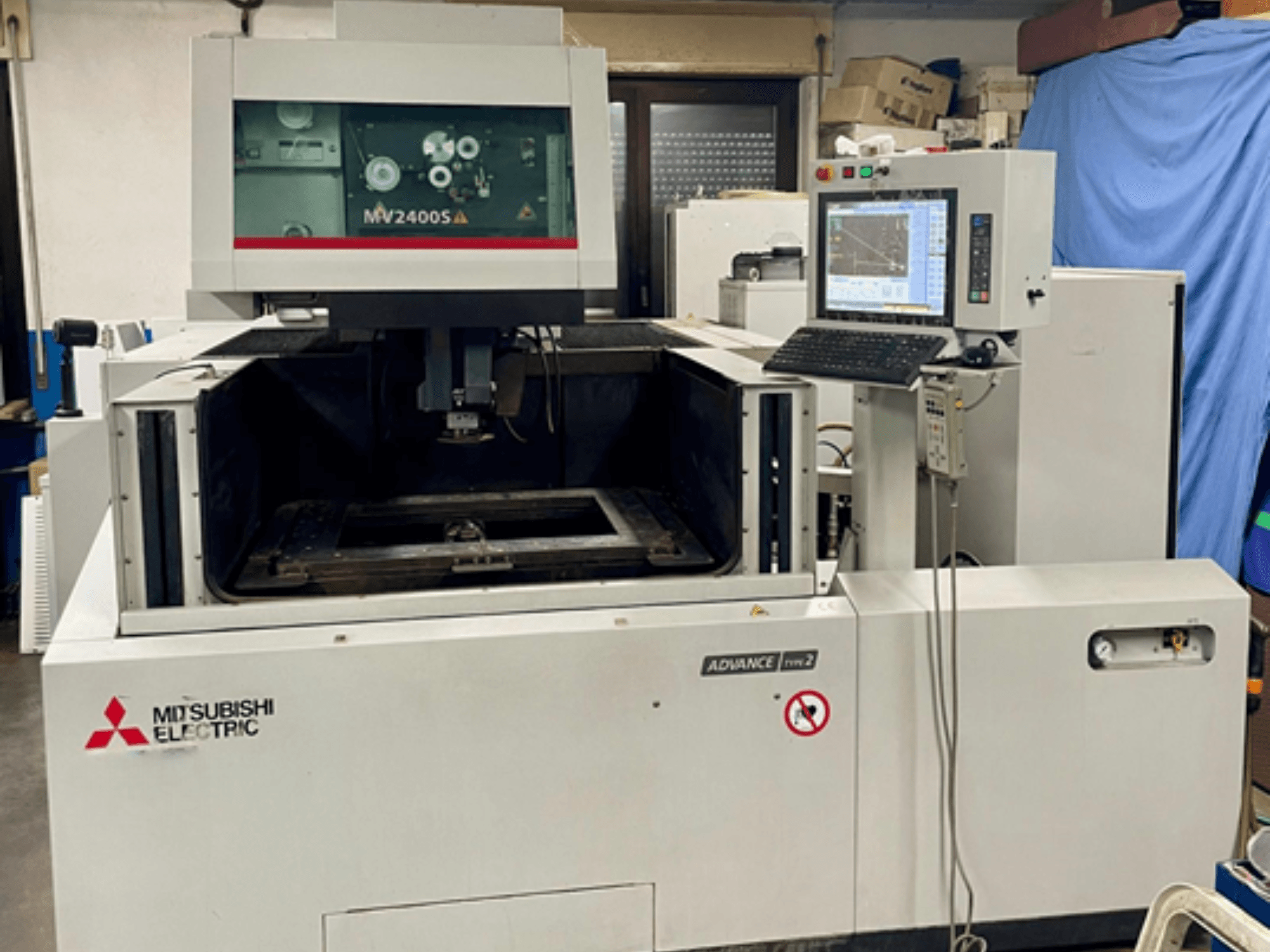 Mitsubishi MV 2400S Wire EDM machine, front view, with a control panel and visible work area for precision cutting.