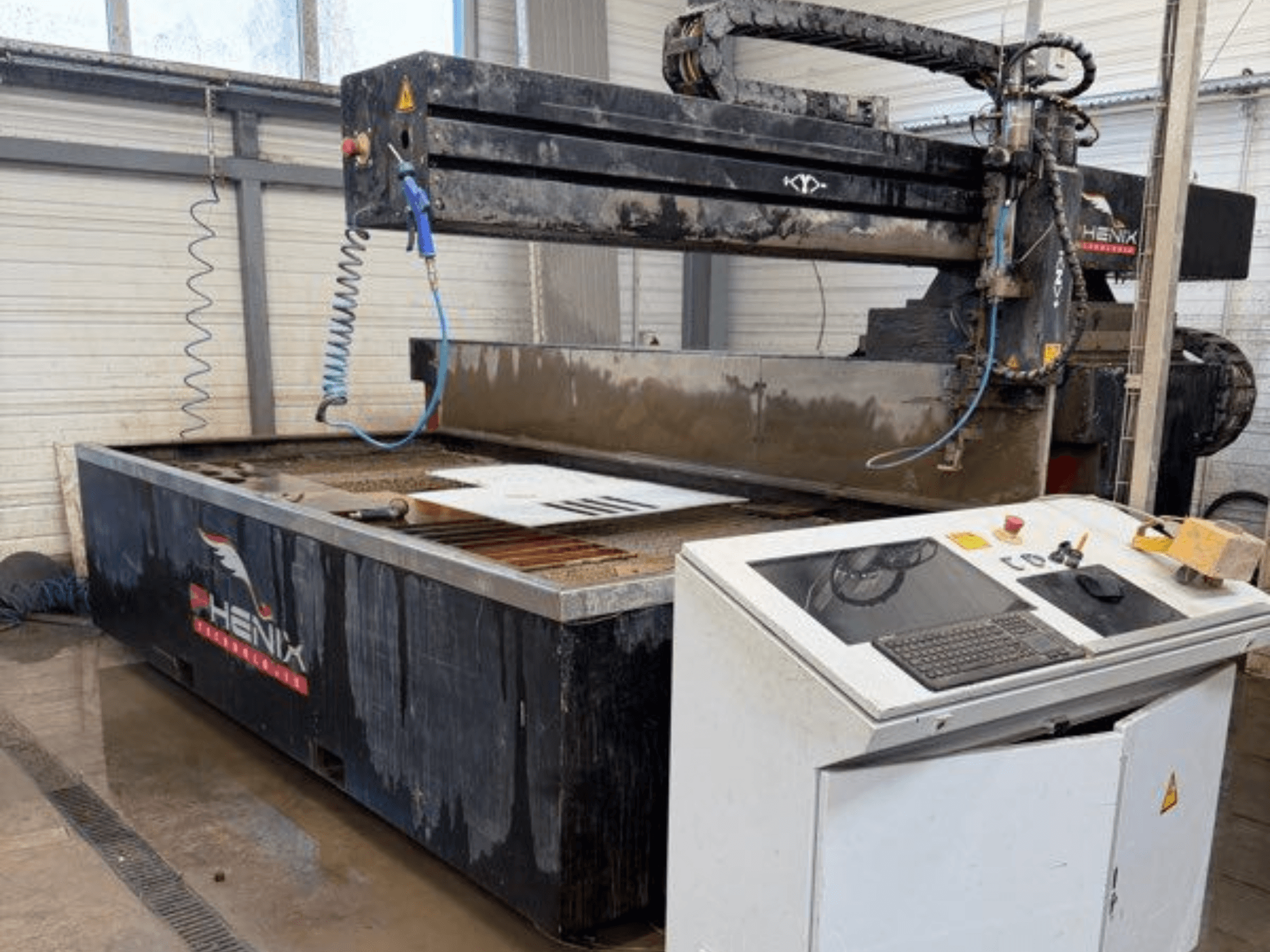 PHENIX MD JET 1530 waterjet cutting machine, front view showing control panel and cutting area with visible water tank.