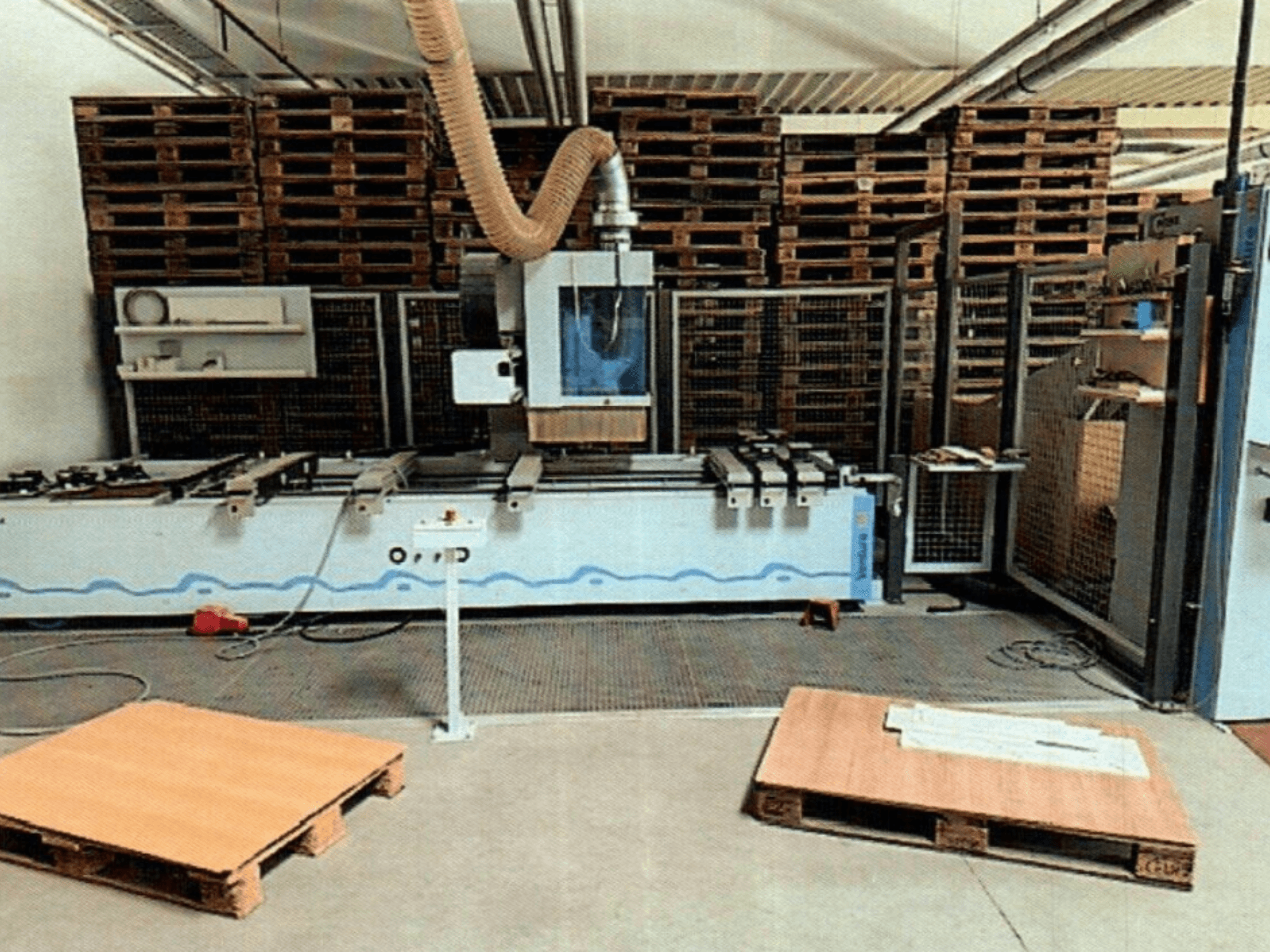 CNC wood machining center Weeke Venture 1M in a workshop, front view with wooden pallets visible and industrial setup.