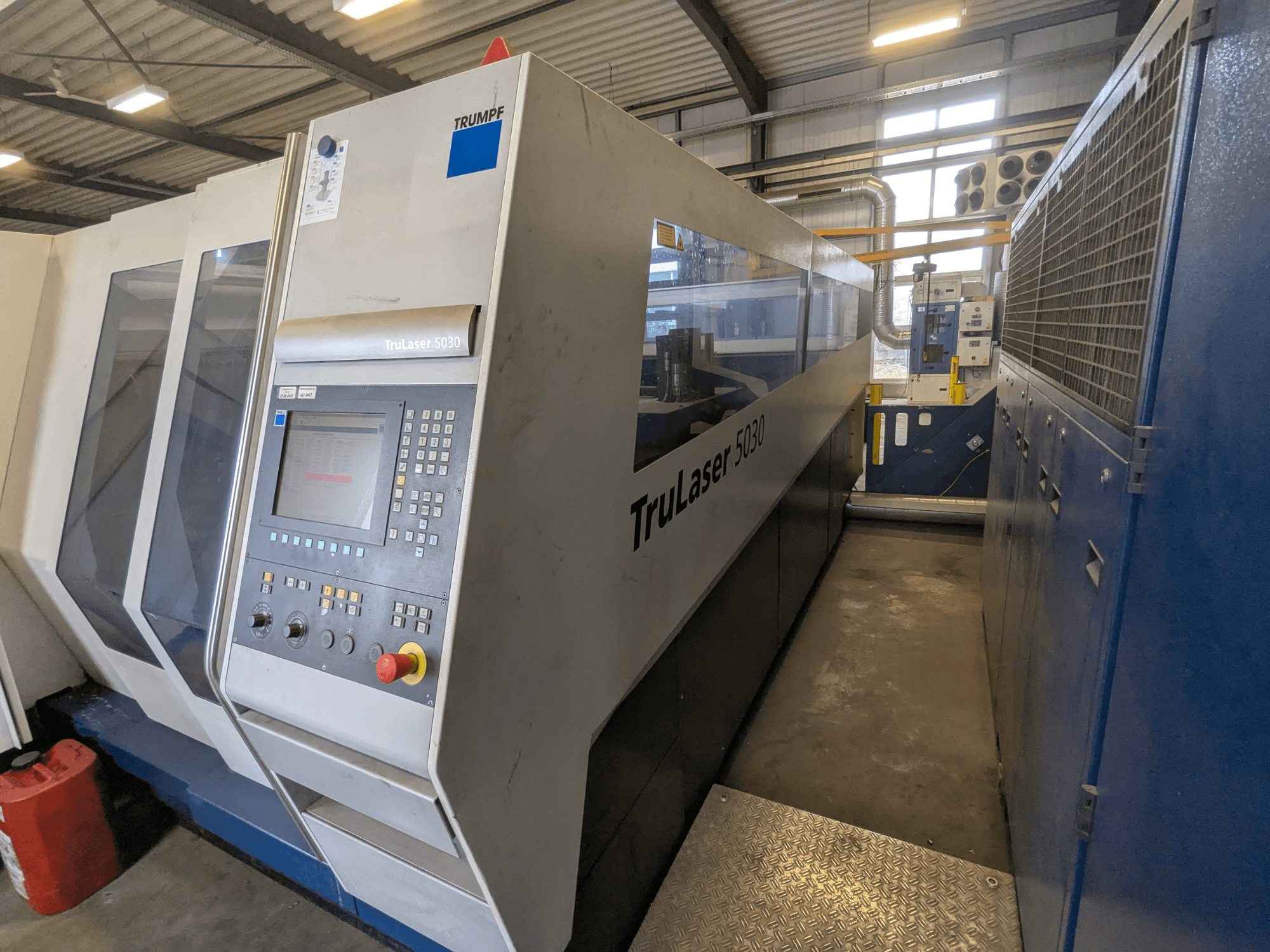 TRUMPF TruLaser 5030 CO2 laser cutting machine, front view showing control panel and sleek design, in industrial setting.