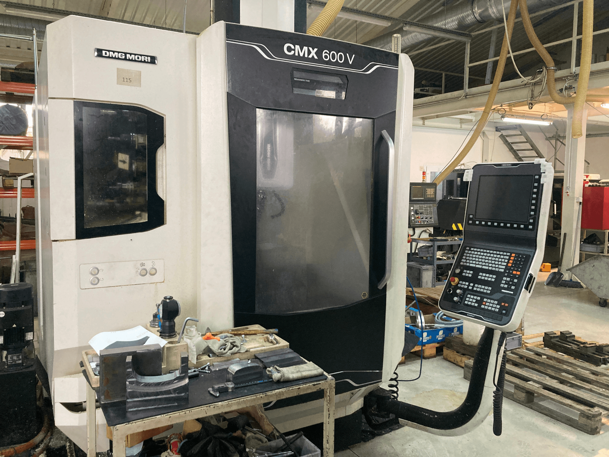 DMG MORI CMX 600 V milling machine viewed from the front, showcasing the control panel and worktable with tools.
