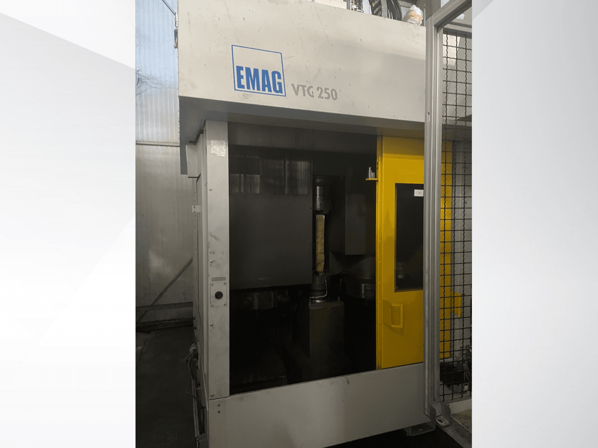 EMAG VTC 250 vertical machining center in front view, featuring a yellow door and a visible cutting tool inside the chamber.