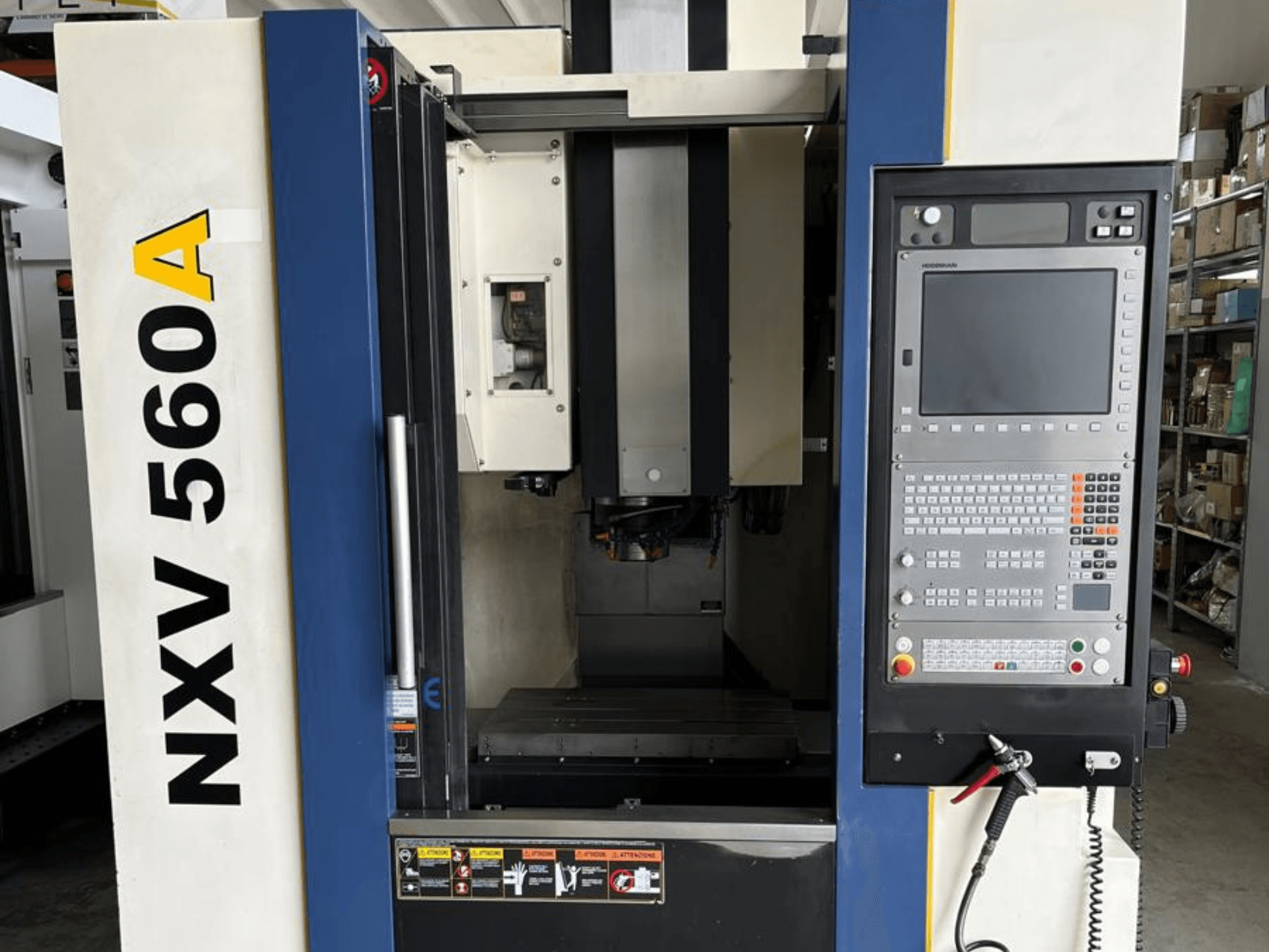 NXV 560A CNC machine viewed from the front, featuring a control panel with buttons and a digital display.