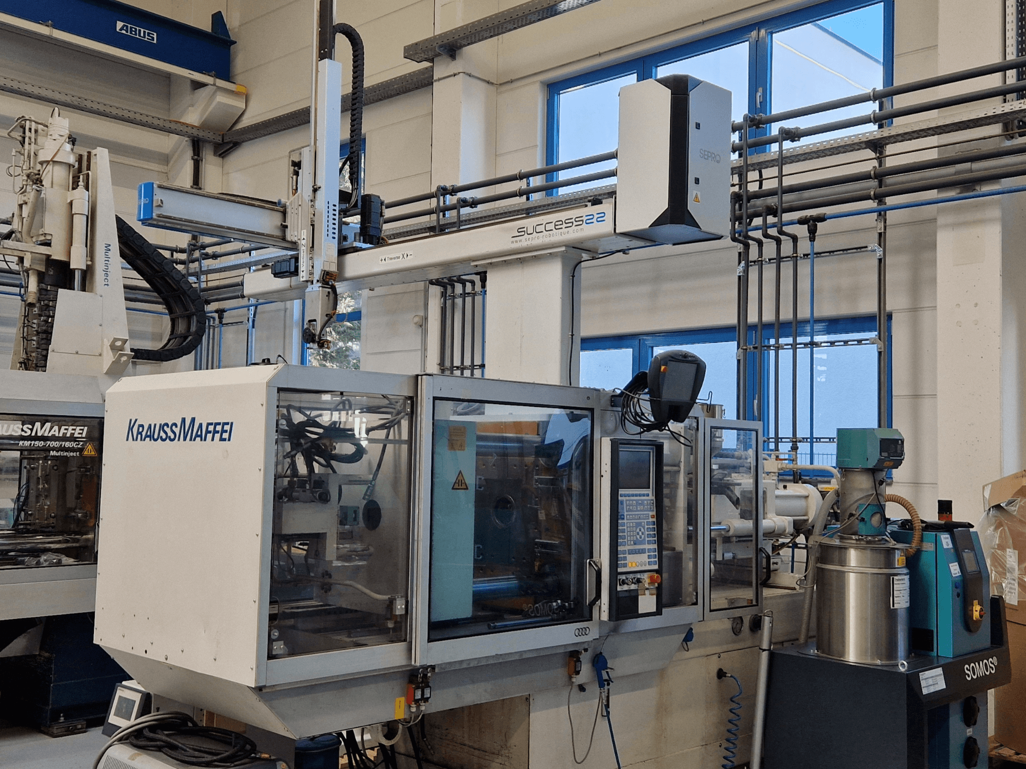 KraussMaffei Success 22 injection molding machine with control panel, viewed from the front in a factory setting.