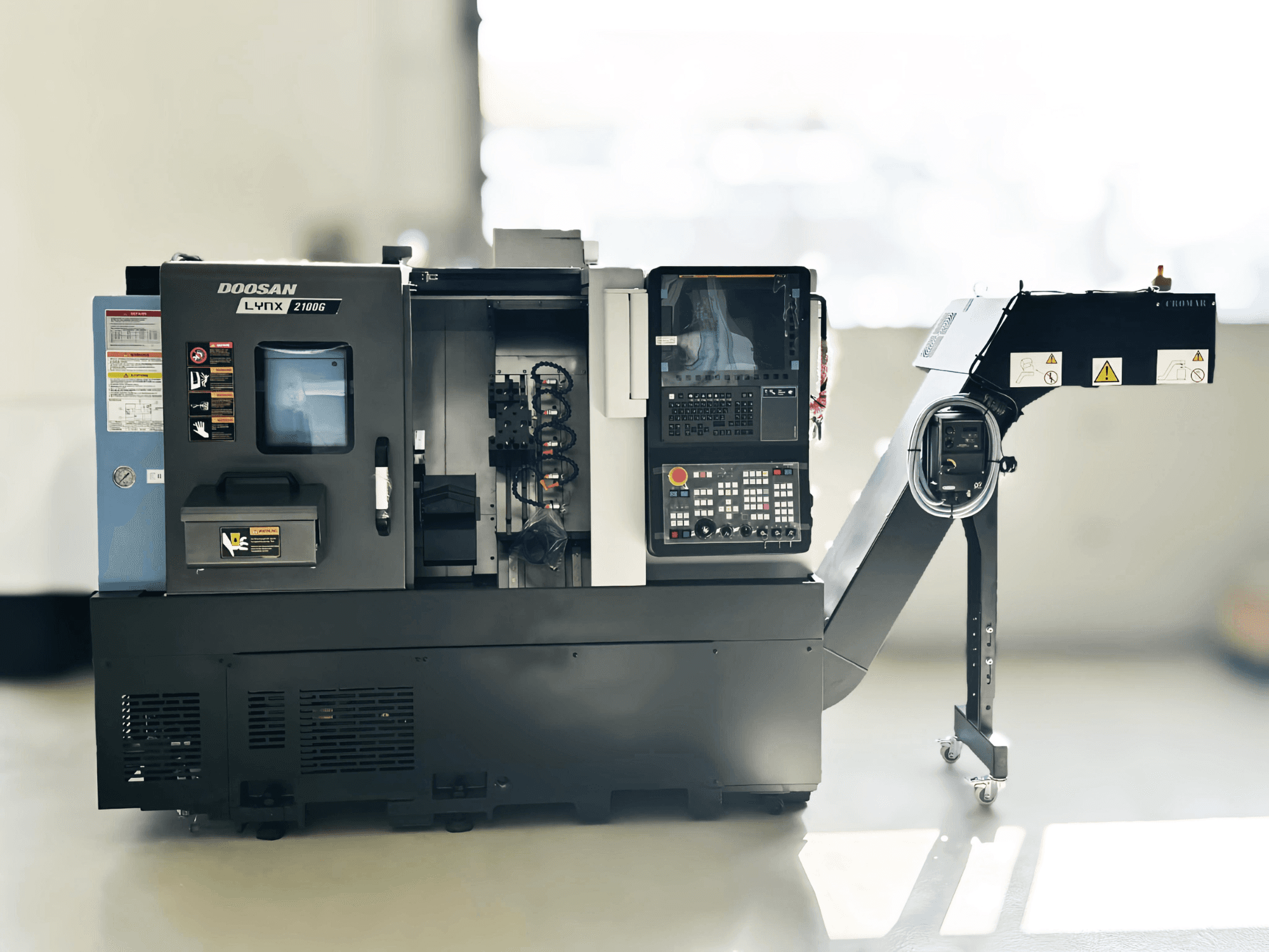 DOOSAN LYNX 2100GA Swiss type turning machine in side view with control panel and tool holder visible.
