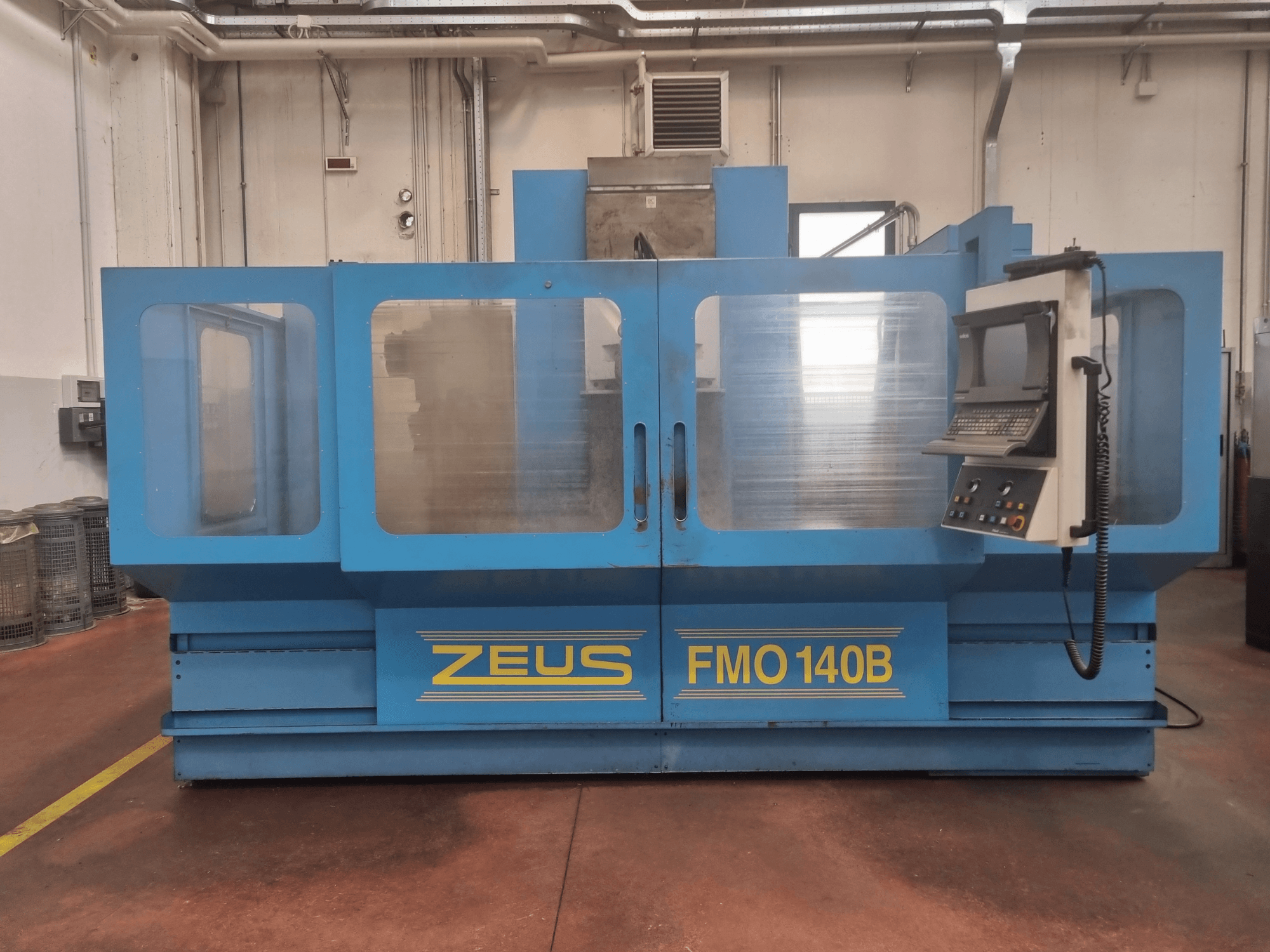 Zeus FMO 140B machine in blue, front view; features control panel and large transparent panels for visibility.