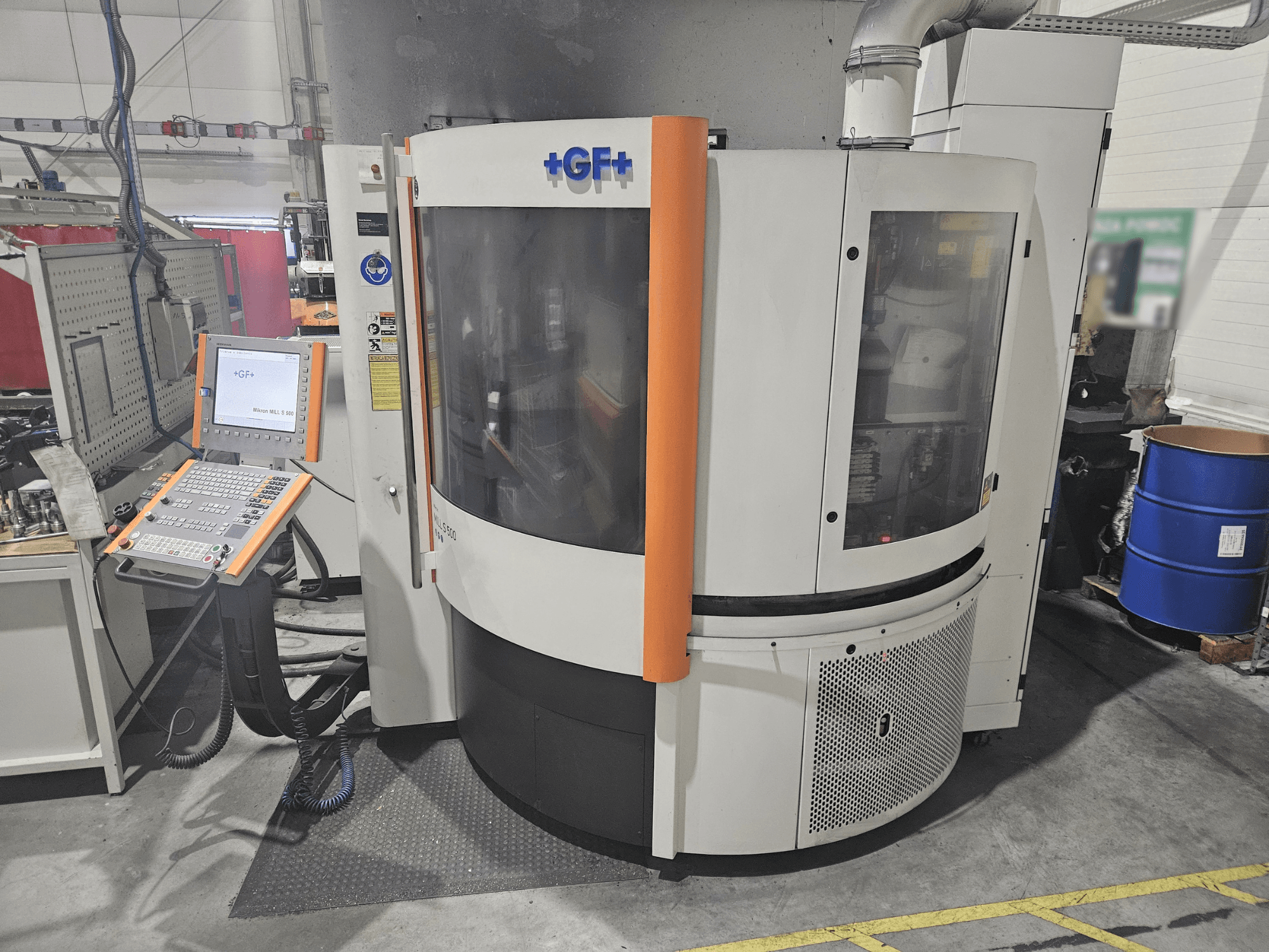 GF Machining Solutions machine tool with control panel, front view; features transparent panel, orange accents, and industrial setting.
