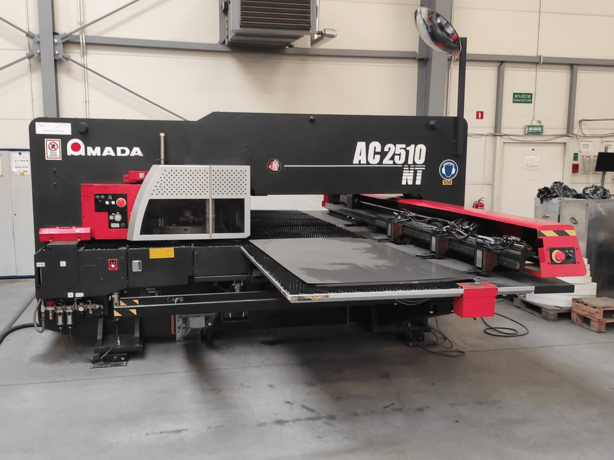 Amada AC2510 NT CNC punching machine, front view, featuring a control panel and sheet loading area.