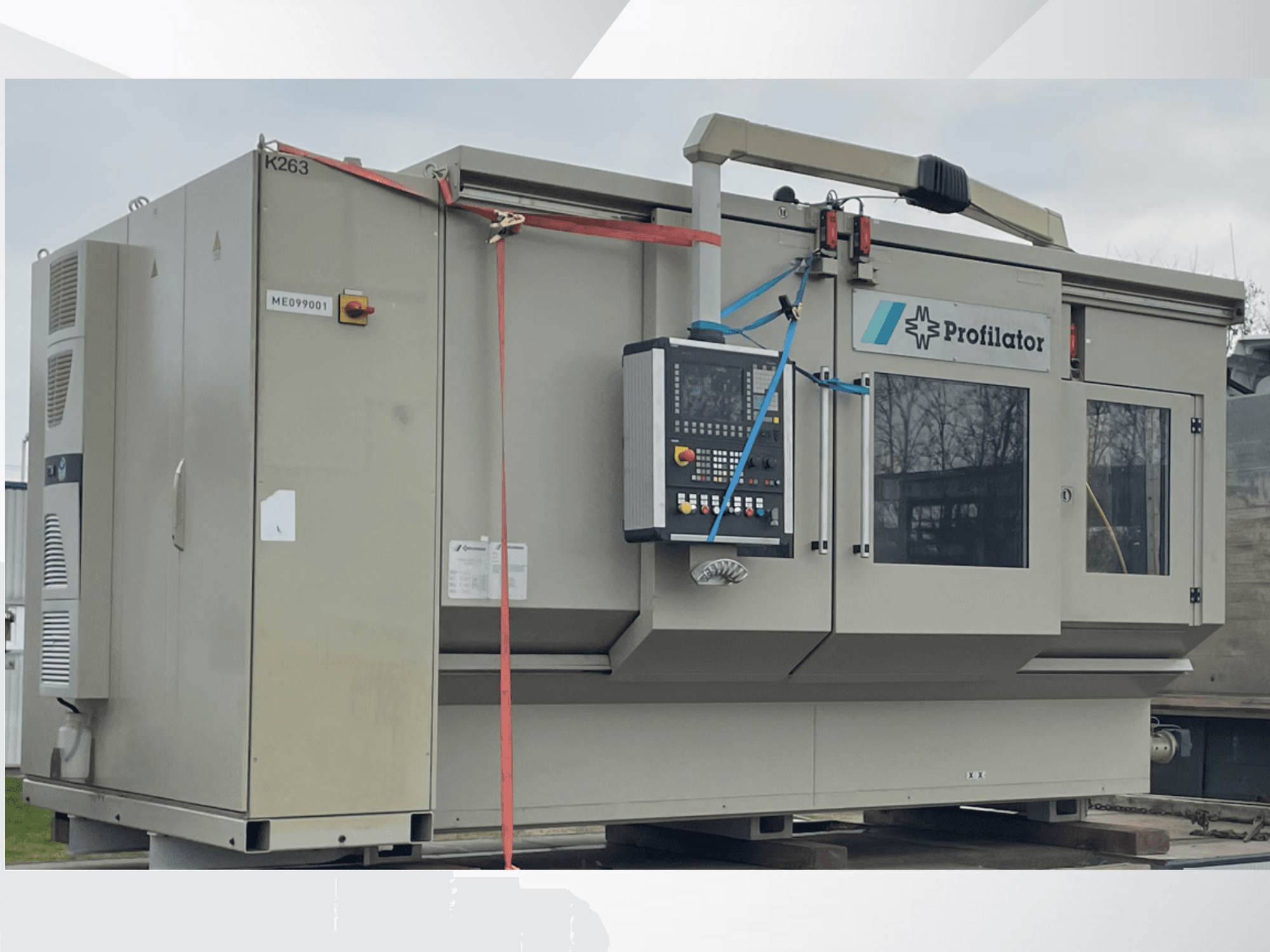 Profillator machine in side view, featuring control panel, safety labels, and protective strapping, on a wooden platform.