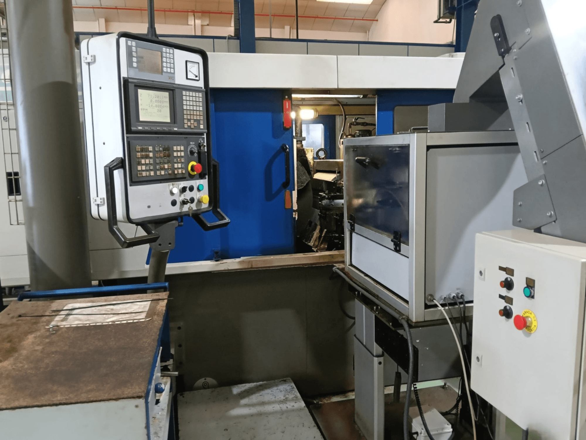 Control panel and machinery of DANOBAT 327 MDA centerless grinding machine, viewed from the side, showcasing buttons and display.