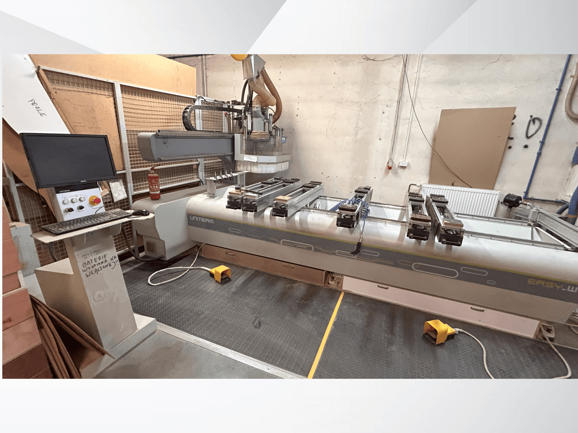 Front view of a UNITEM EASY-W CNC machine, featuring a control panel, monitor, and clamped workpieces on the working table.