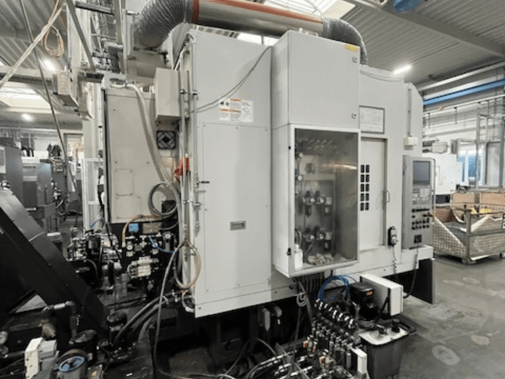 Industrial machine side view featuring control panel and hydraulic components, showcasing brand and model details.