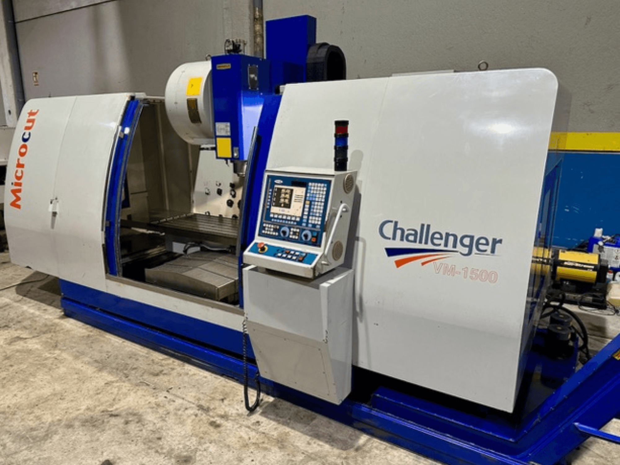 Microcut Challenger VM-1500 CNC machine, front view, features control panel, workspace, and a blue base.