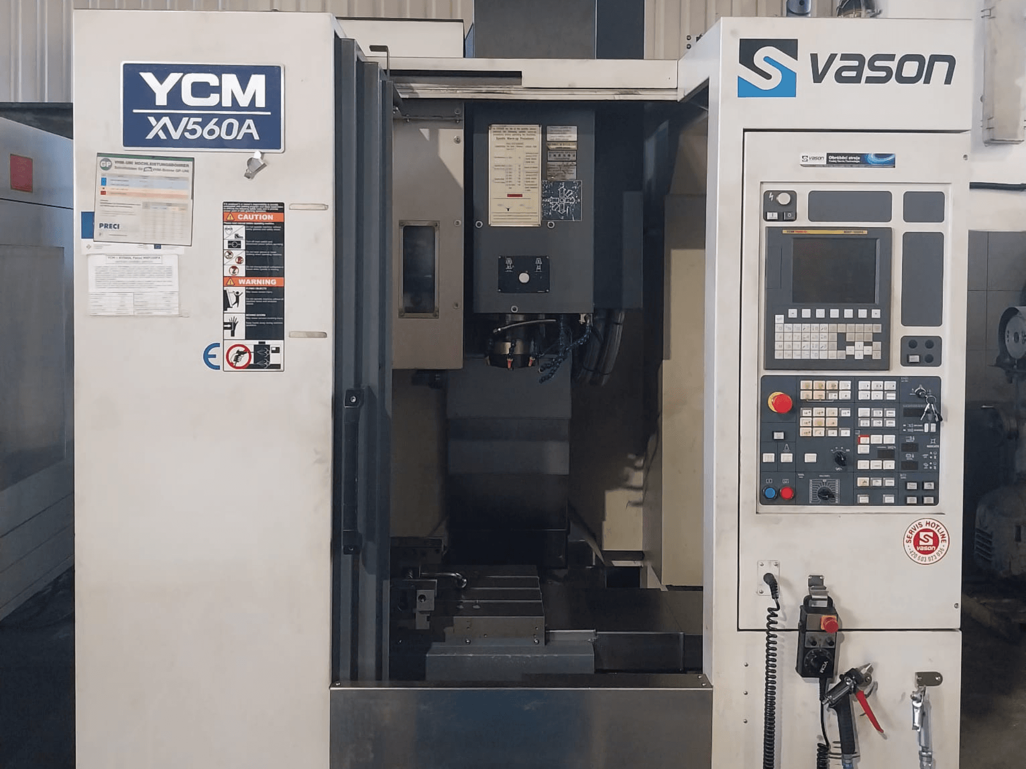 Front view of YCM XV 560A Vertical Machining Centre, featuring control panel and worktable with machining components visible.