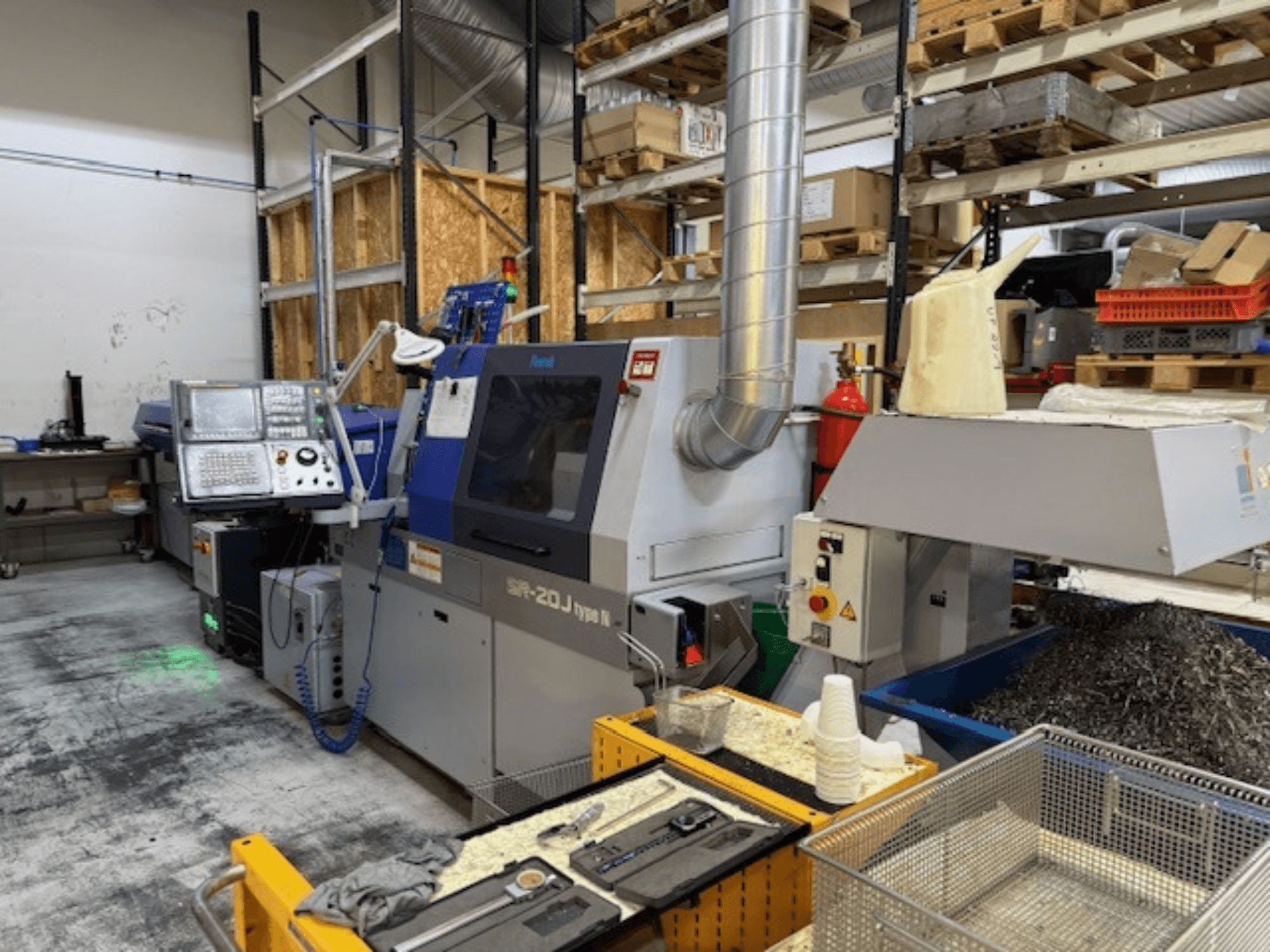Front view of a Faroh SPR-20J type N machining center with control panel, metal shavings, and safety equipment in a workshop.