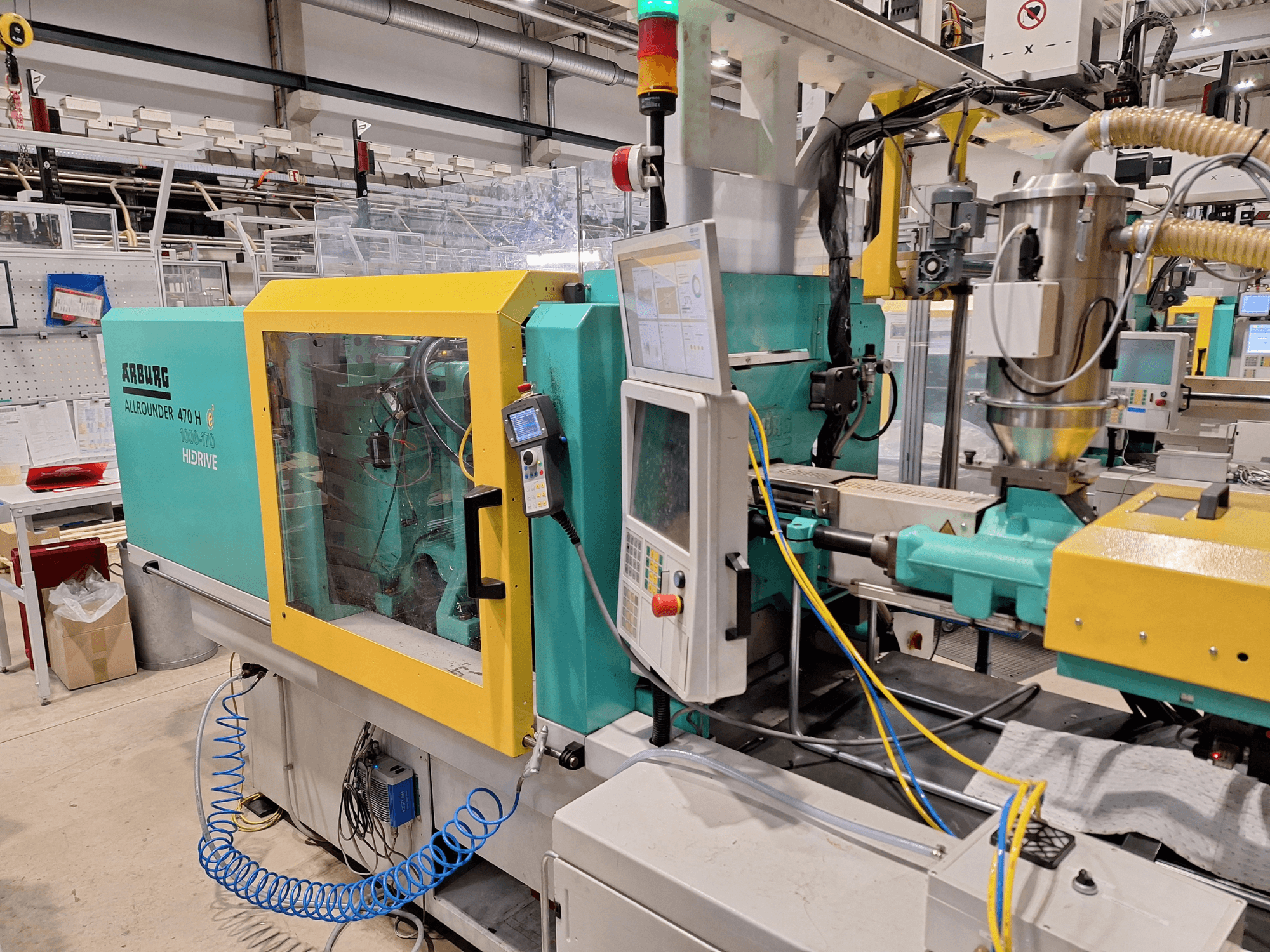 Arburg 470 H 1000-170 hydraulic injection moulding machine, side view showcasing control panel and feeding system.