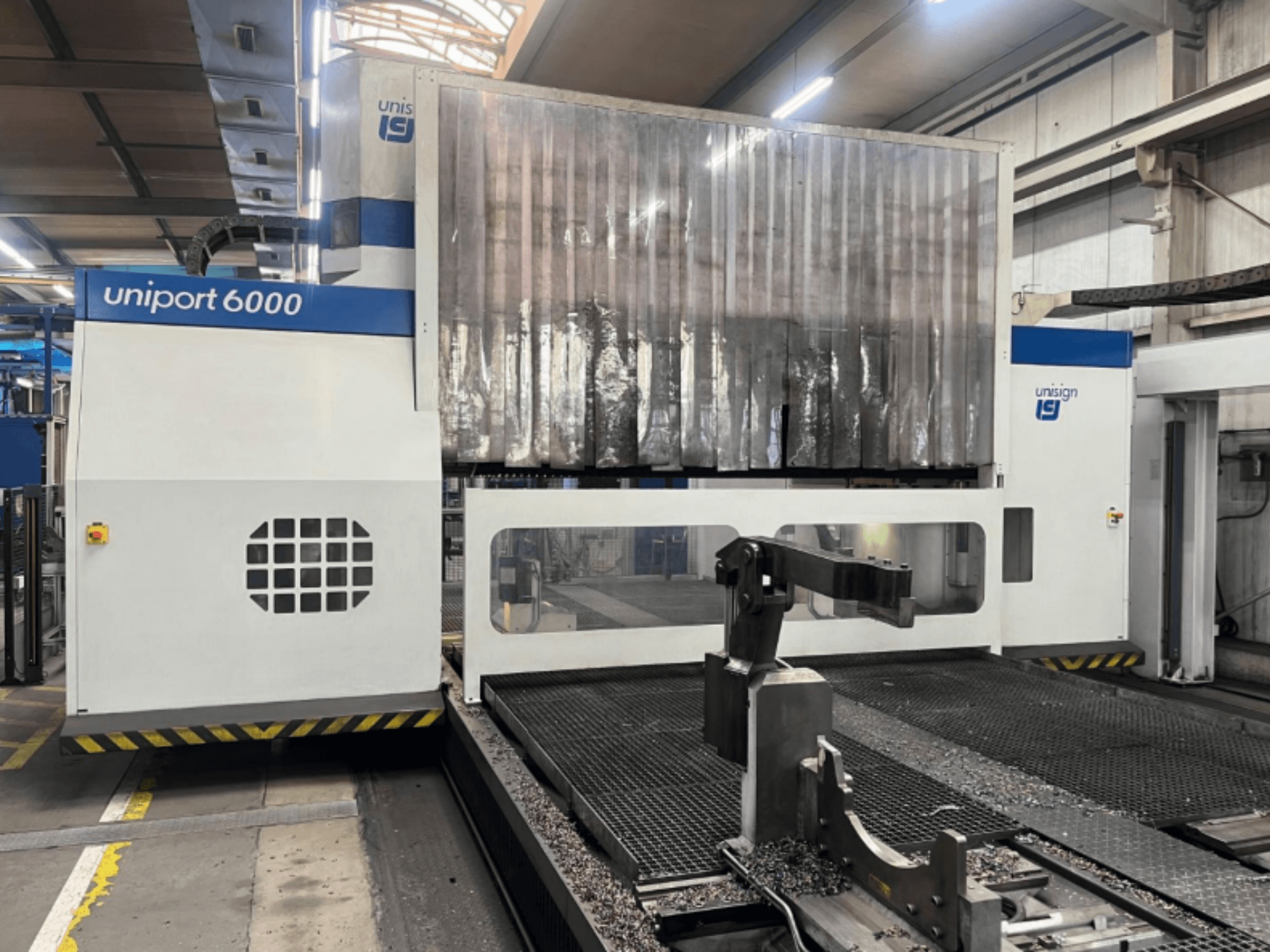 Gantry milling machine Unisign uniport 6000, front view, showcasing the machine structure and cutting area with metal shavings.