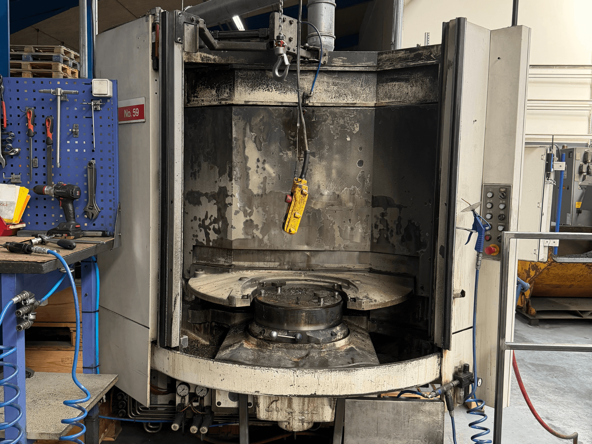 Horizontal machining centre HELLER MC 16 front view, revealing an empty worktable and control panel, in workshop setting.