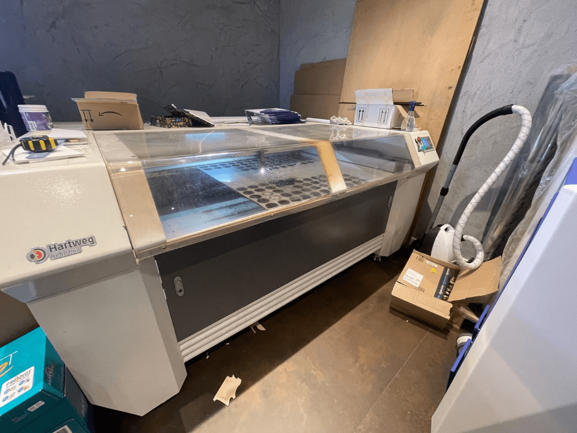 CO2 laser cutting machine Bodor CL-1610XUF in side view, showing work area with material slots and control panel.