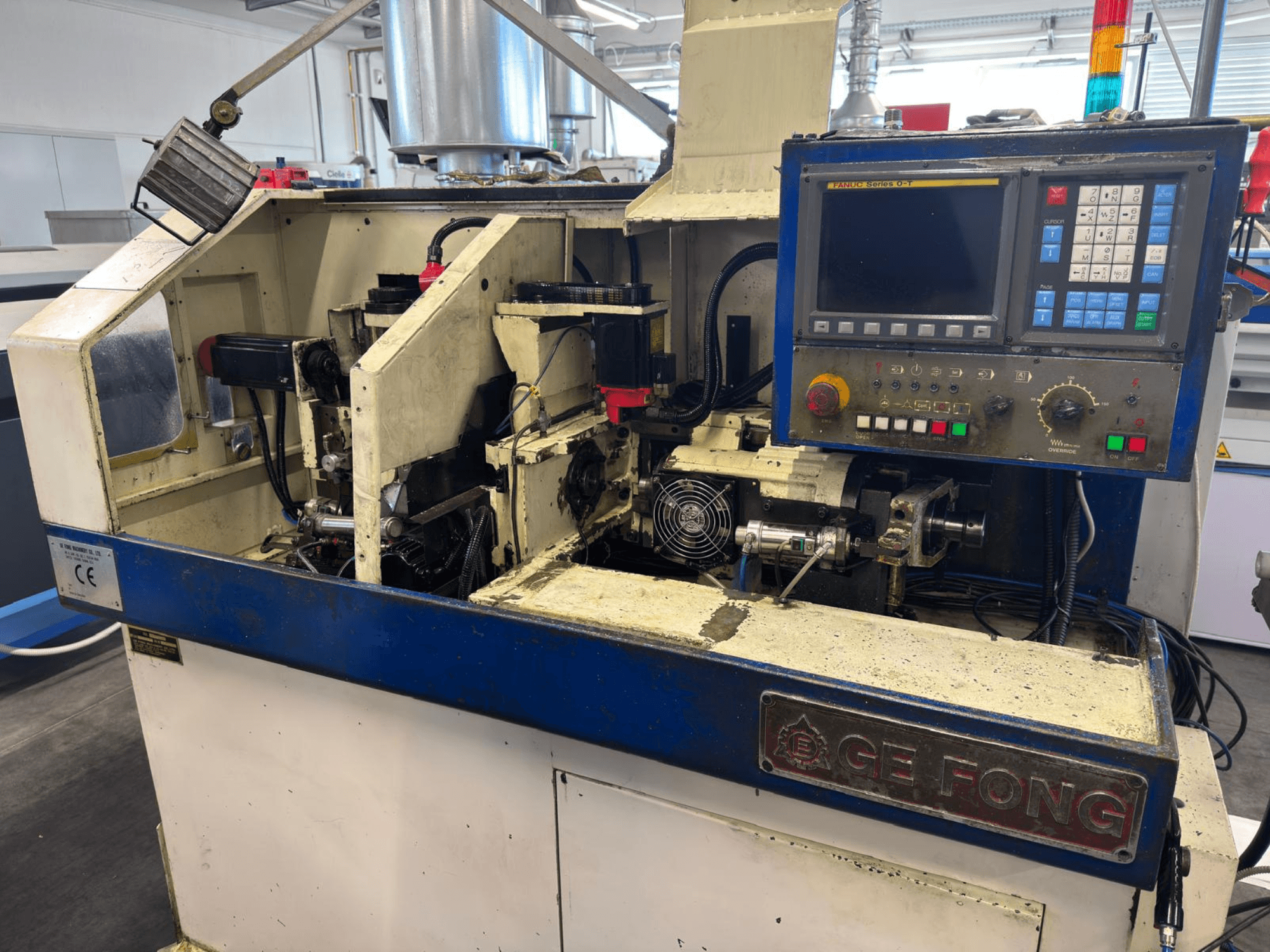 GE FONG industrial machine in a front view, showing internal components, control panel, and operational parts.