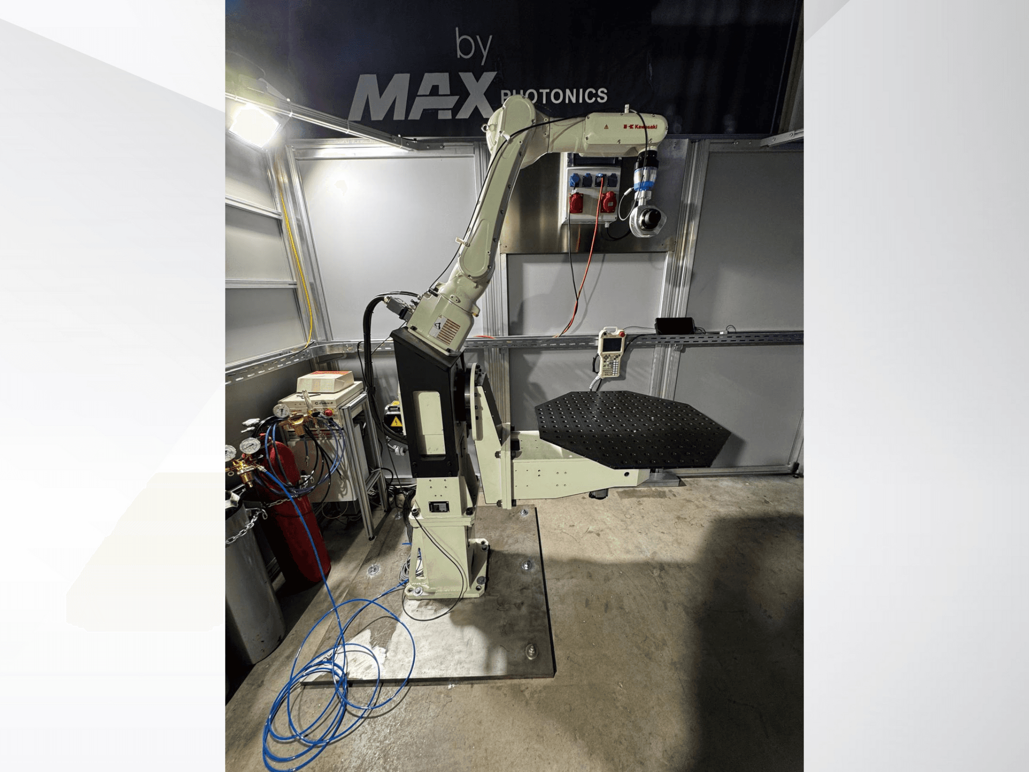 Max Photonics robotic arm apparatus, front view, featuring a black perforated platform and control panel with gauges and cables.