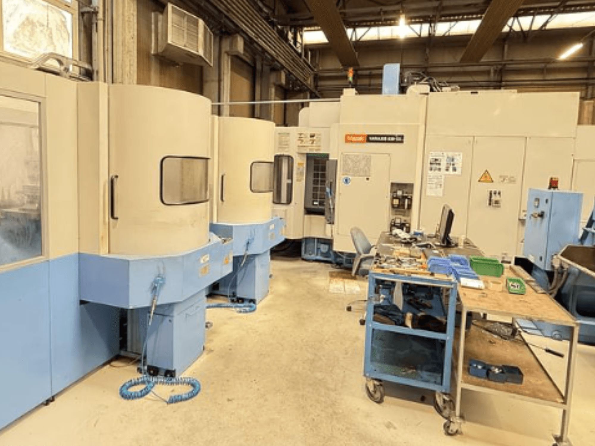 Mazak Variaxis 630-5X vertical machining center in a workshop, front view showing control panel and tool storage area.
