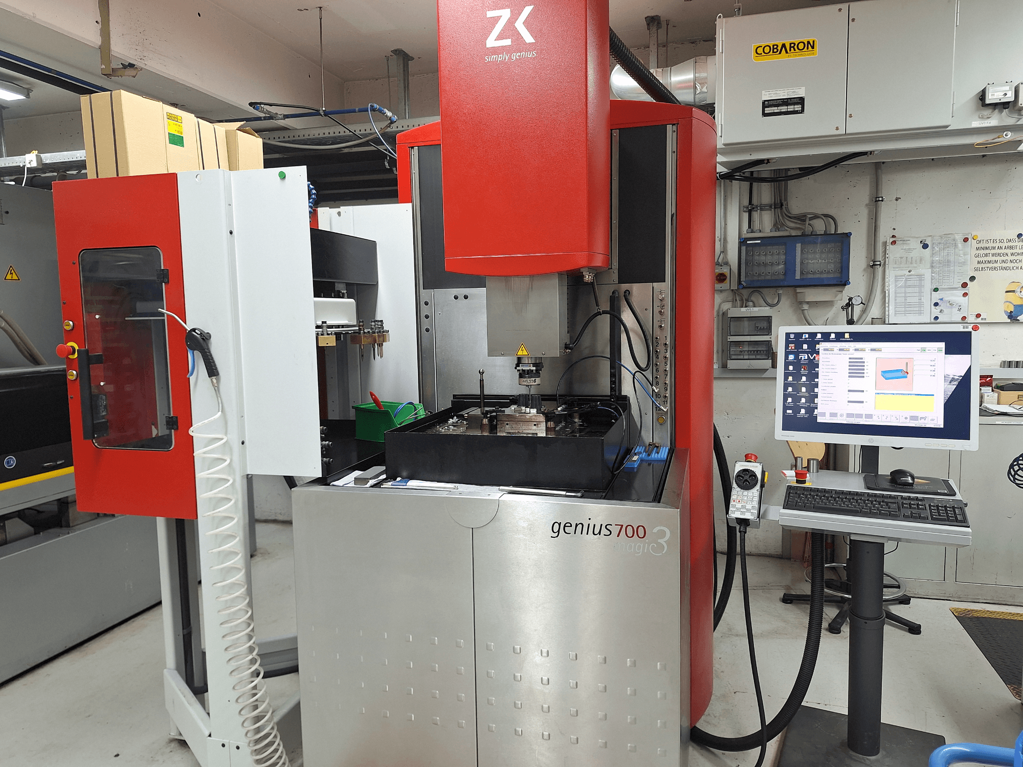 Genius 700 milling machine from ZK, front view, featuring a touchscreen control panel and machining area with tools and materials.