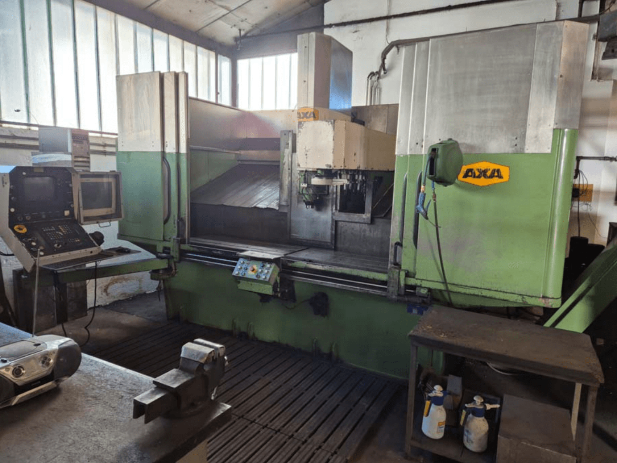 AXA VSC-2M vertical machining centre, front view, features control panel and work area with cutting tools and cleaning supplies.