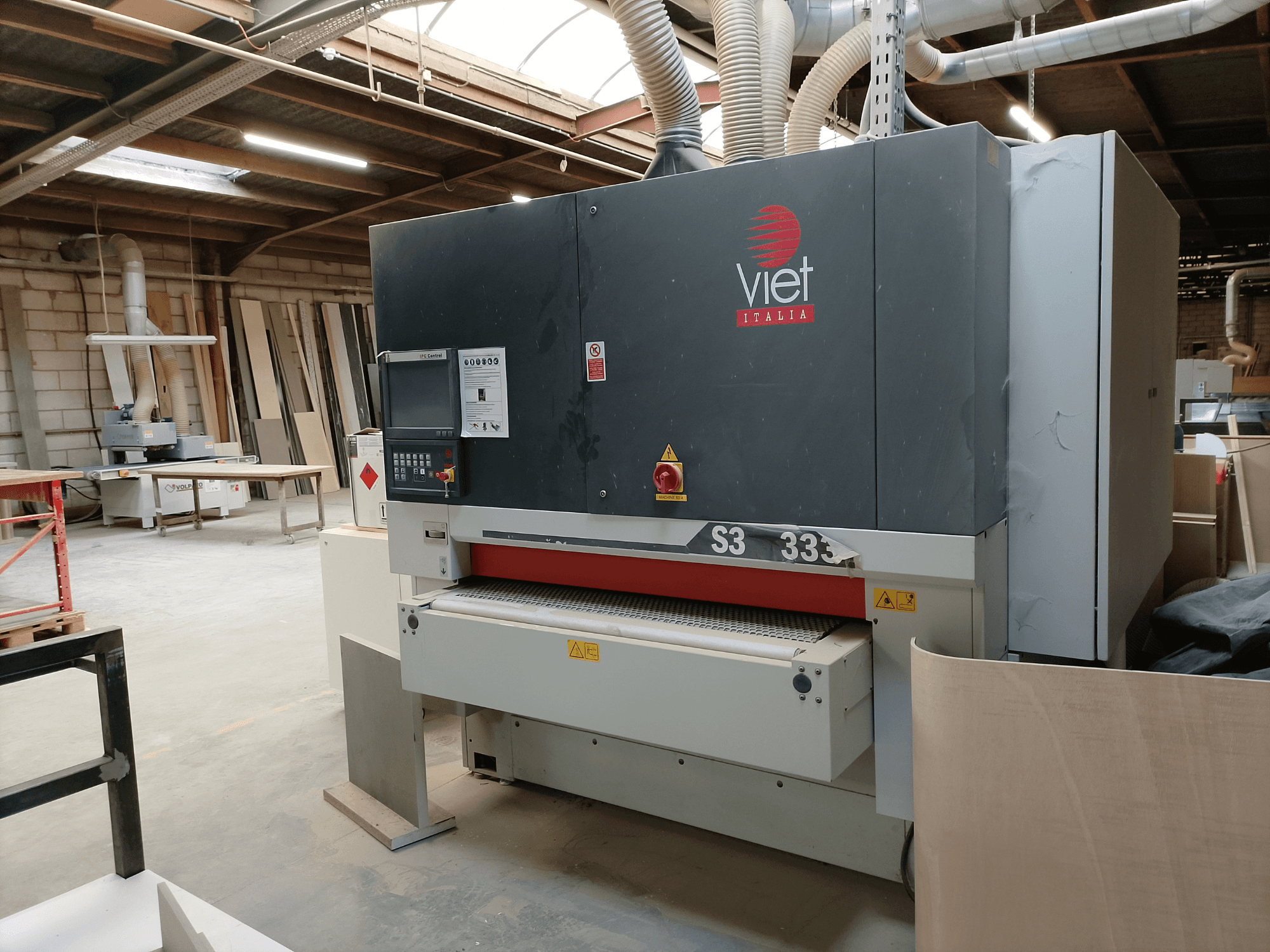 Belt sander by Viet, model S3 333, front view, showing control panel and sanding surface in a workshop setting.