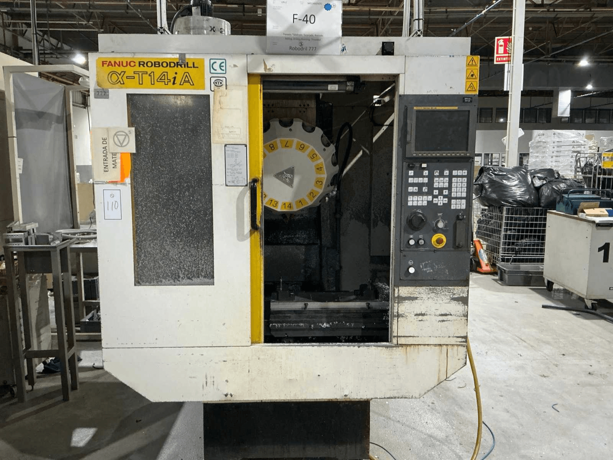 FANUC ROBODRILL α-T14iB vertical machining center, front view showing control panel and tool carousel.