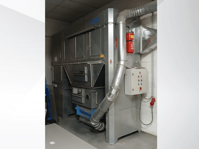 Industrial dust collector unit, gray metal, front view; features exhaust duct, control panel, and fire extinguisher.