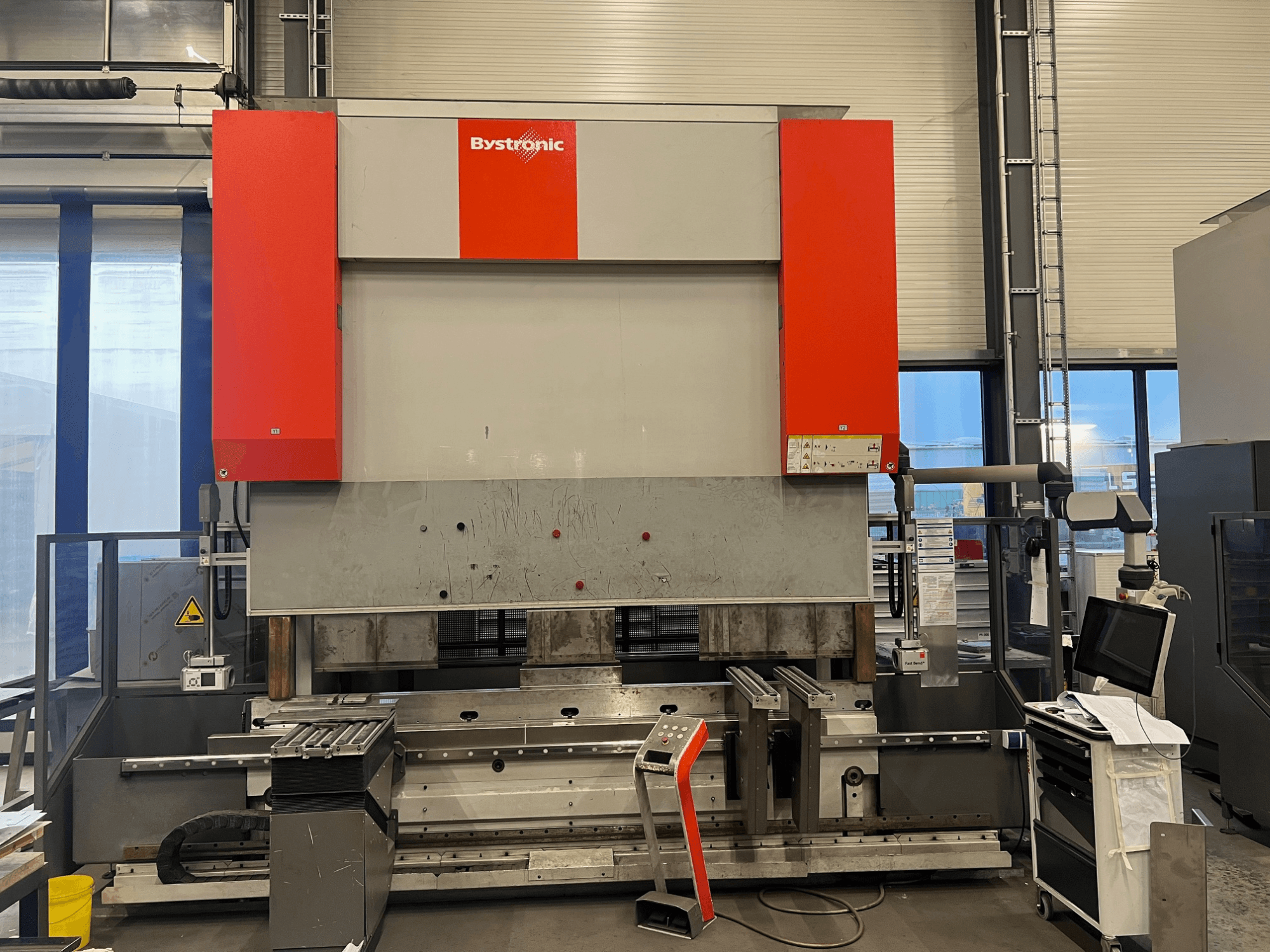 Bystronic sheet metal bending machine in a front view, featuring a sleek design, control panel, and safety features.