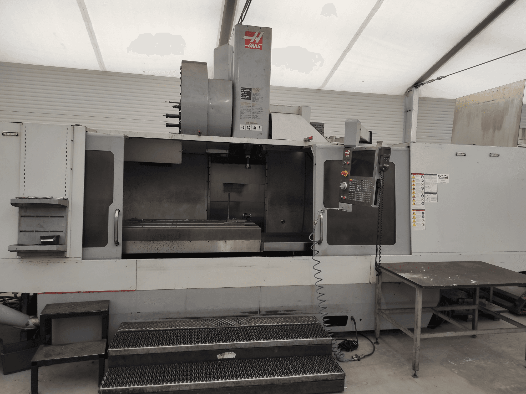 HAAS VF-10/50HE Vertical Machining Centre, front view showing control panel, machine bed, and accessible step for operation.