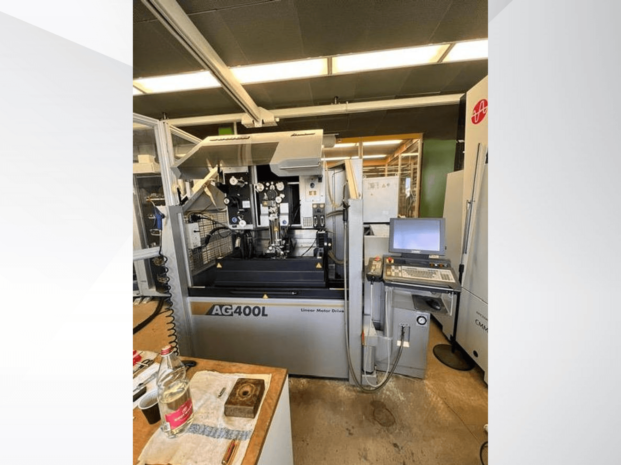 AG400L linear motor drive machine, front view, featuring control panel and work area with safety features visible.