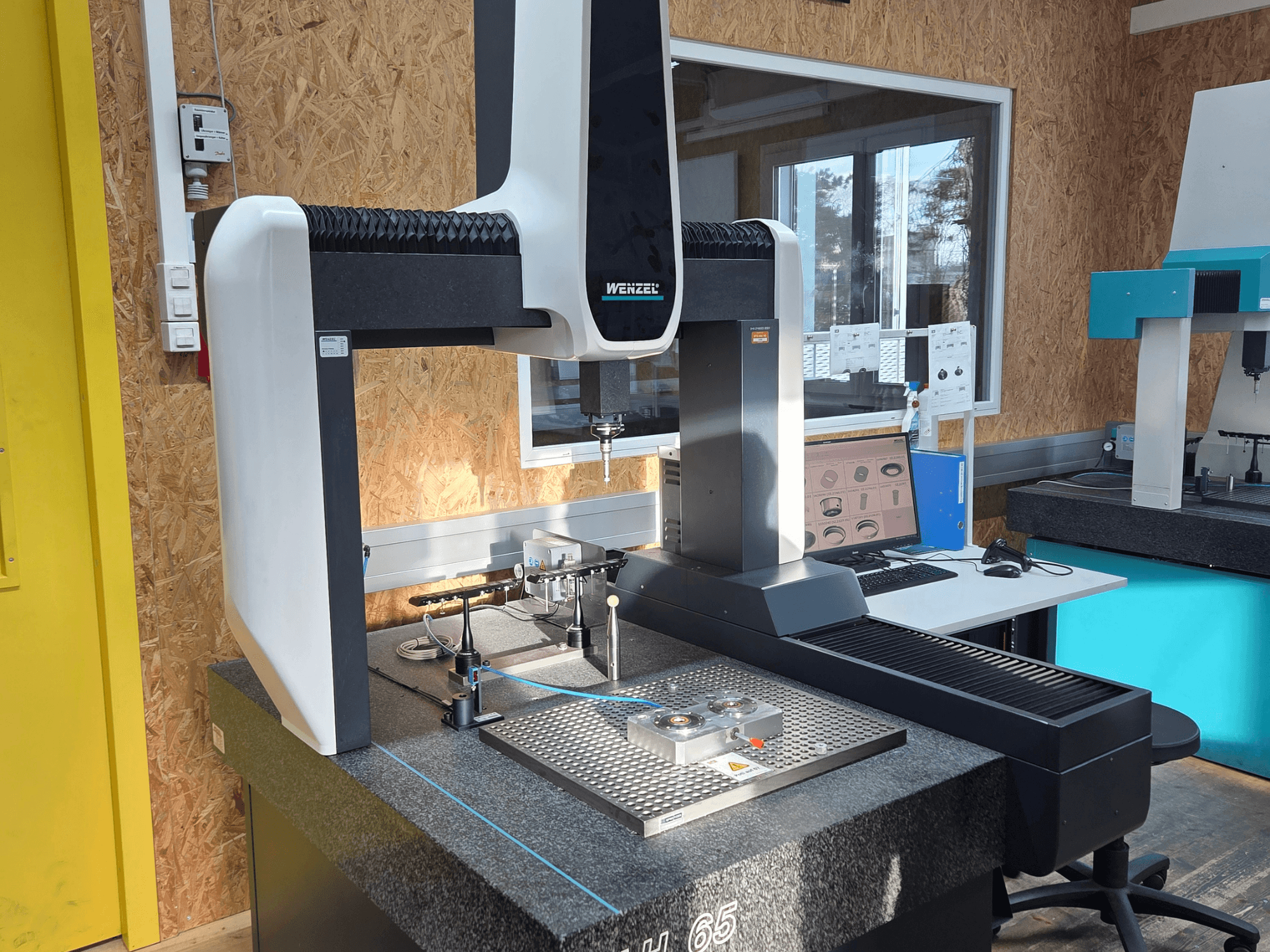 Wenzel LH 65 Coordinate Measuring Machine in a lab setup, front view, displaying measurement tools and a monitor.