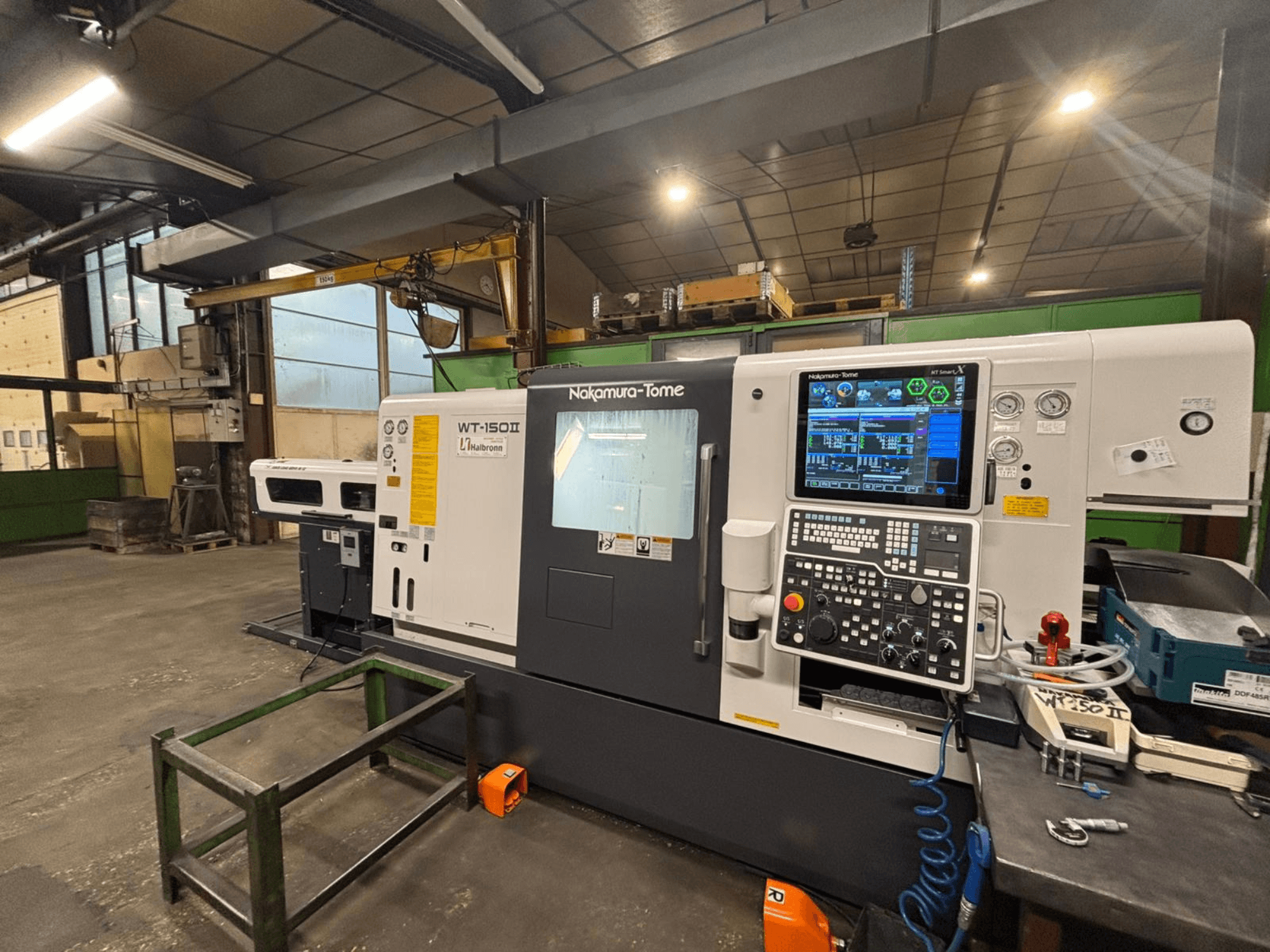 Nakamura-Tome WT-150II machine, front view, with control panel and tools visible on a workbench in a workshop setting.