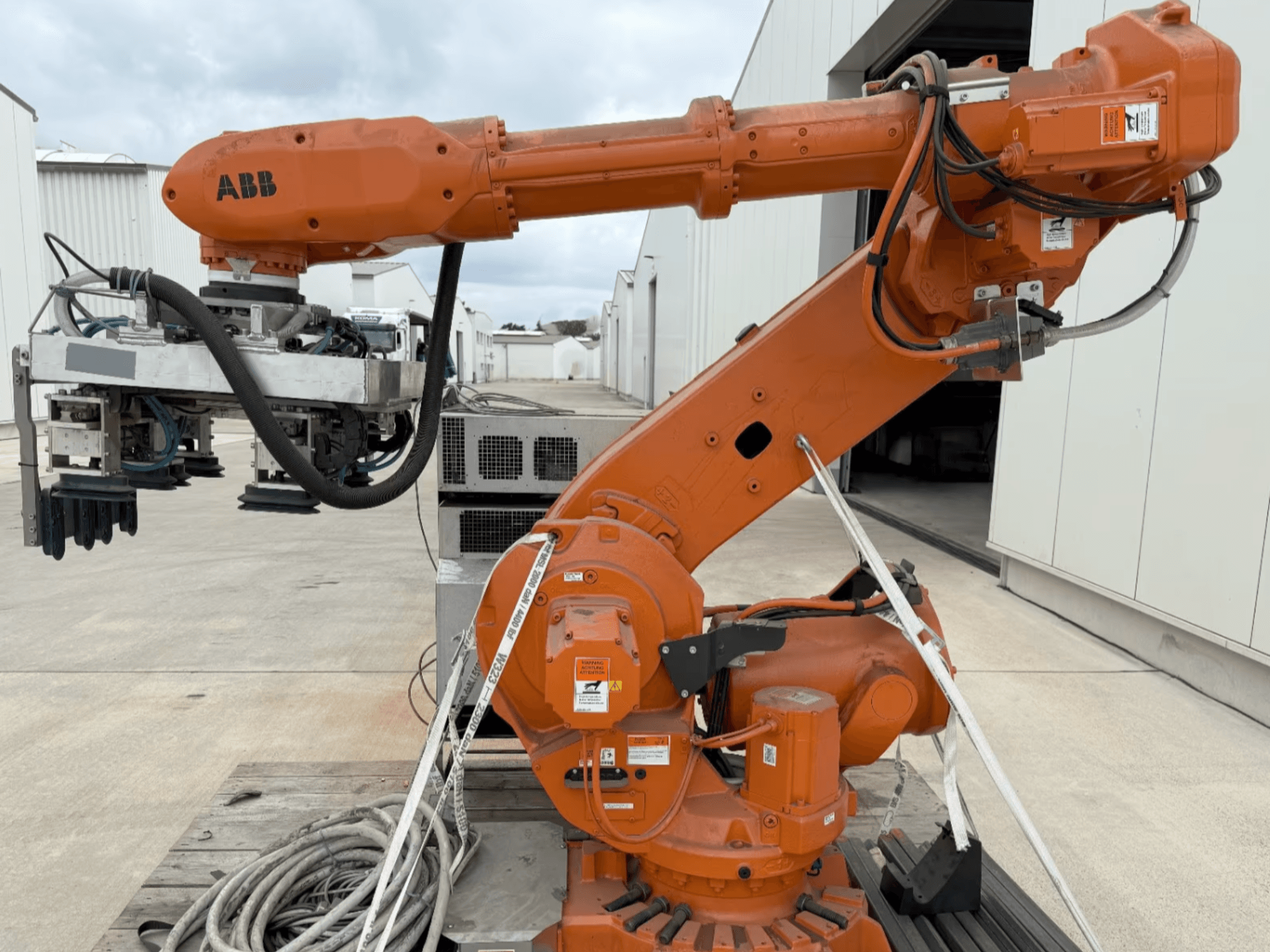 ABB RB 6600-130/3.2 robot arm in side view, featuring an orange robotic arm with a gripper attachment and visible wiring.