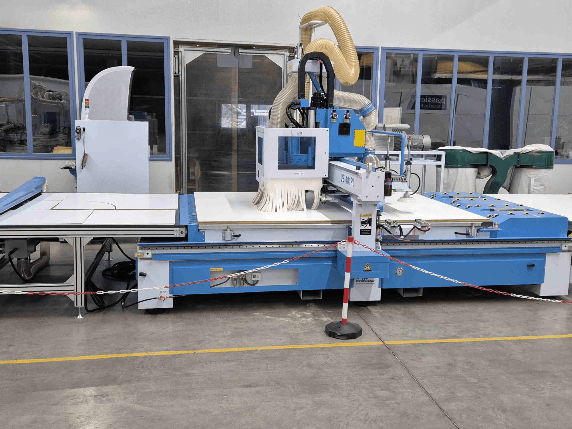 Blue CNC router UE-621PL from the front, featuring a large cutting table and an attached dust extraction system.