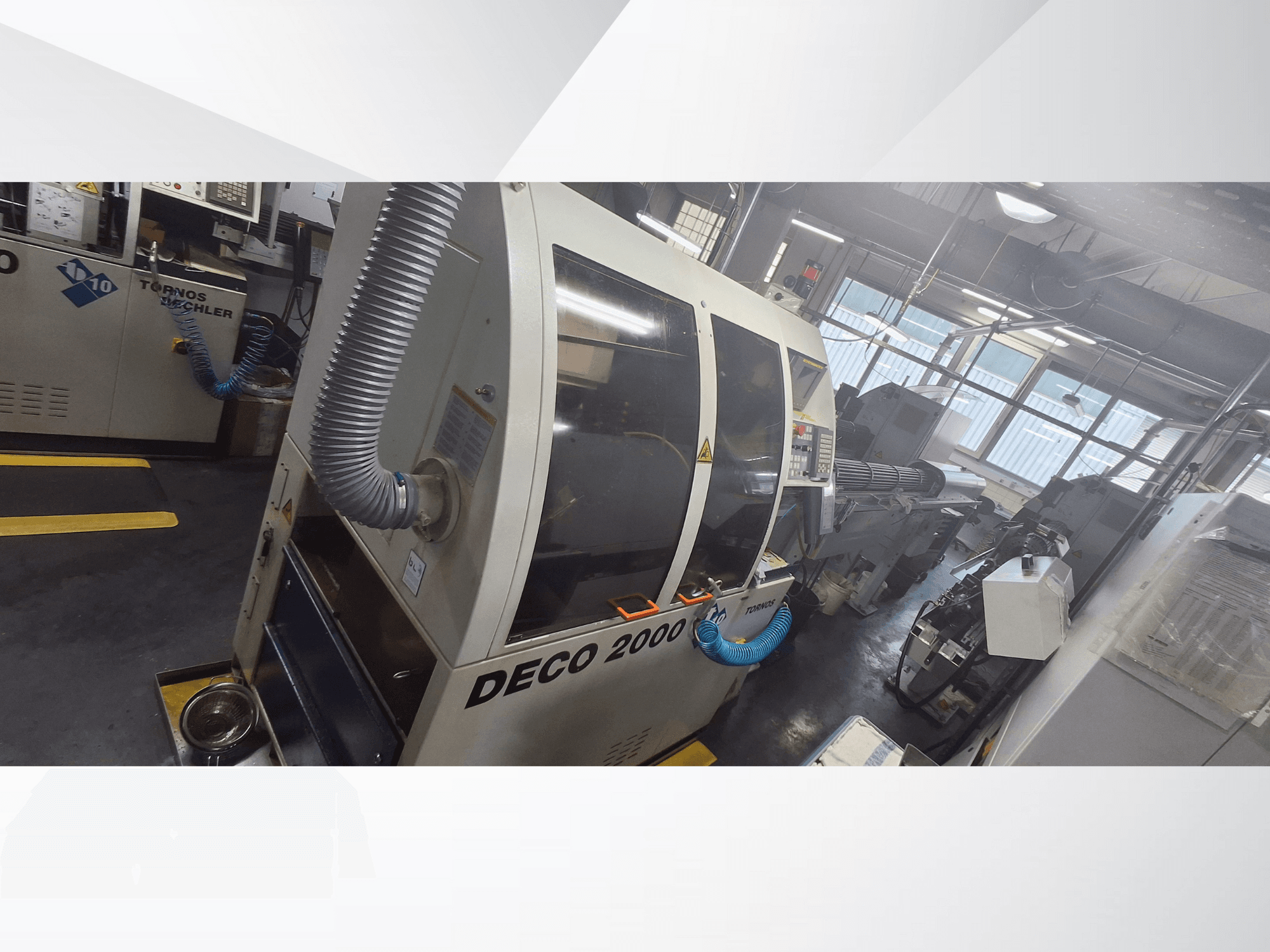 DECO 2000 CNC machine in workshop, front view, features ventilation hose and control panel, designed for precision machining.