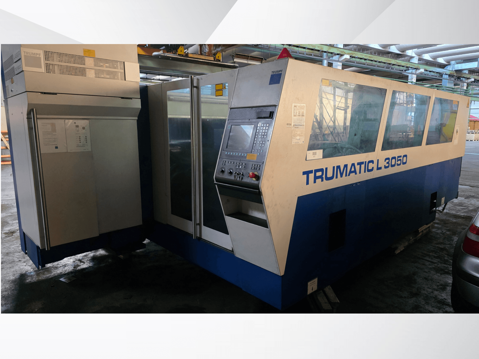 TRUMPF Trumatic L 3050 CO2 laser cutting machine, front view, with control panel and large glass windows.