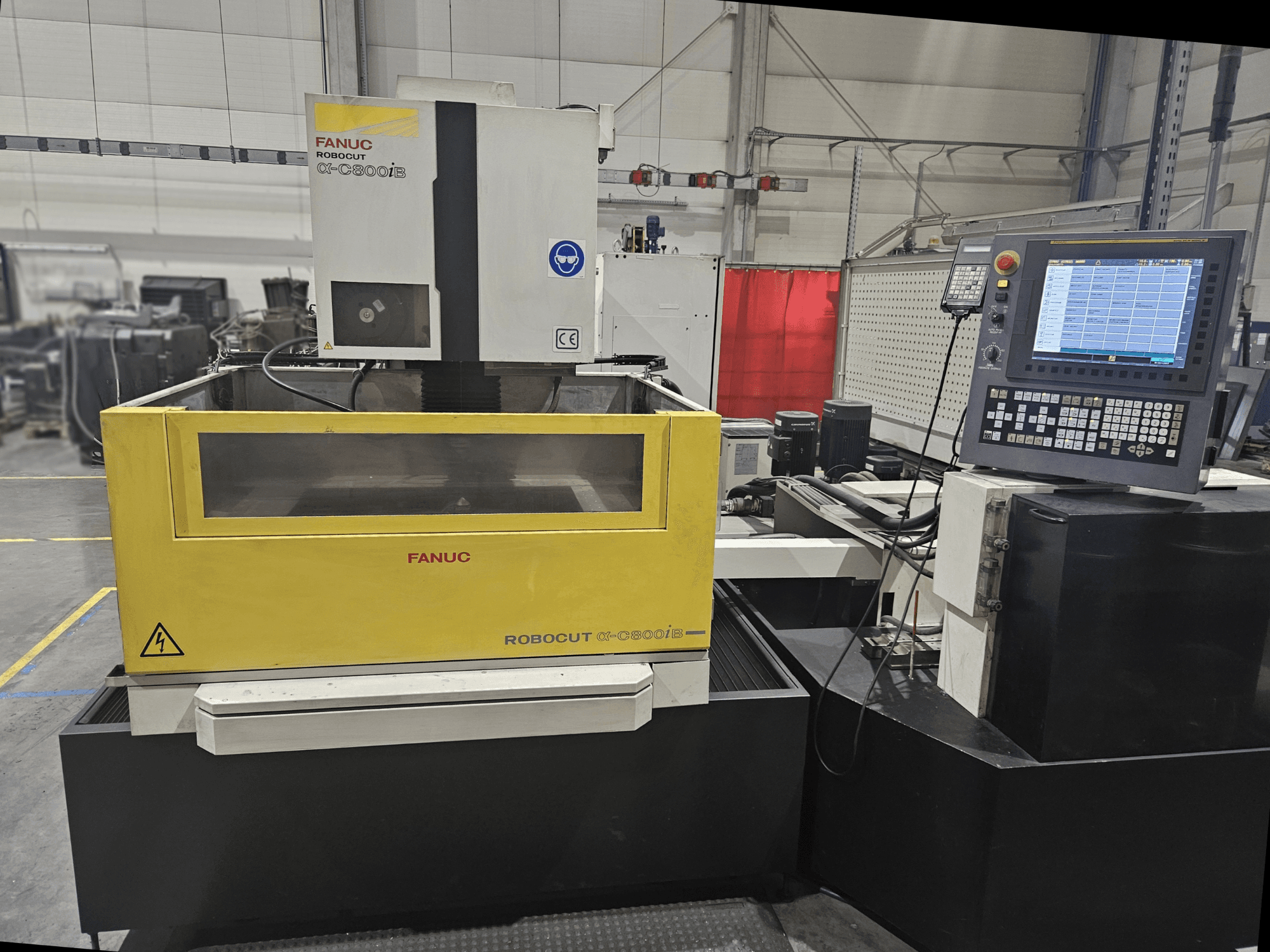 Front view of FANUC Robocut α-C600iB with a yellow and gray machine body, CNC control panel, and operational display.