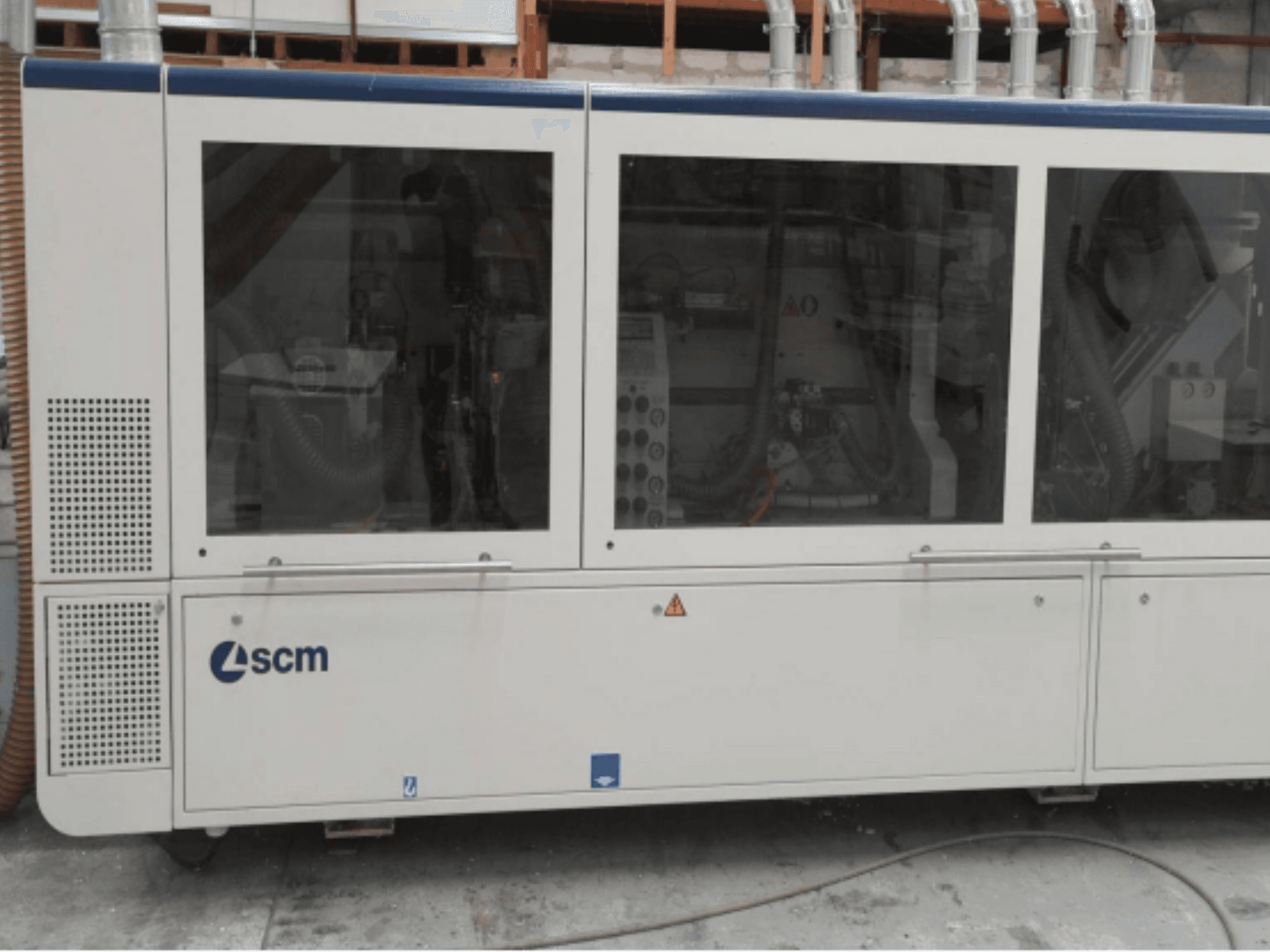 SCM industrial machine, side view, features transparent panels and visible vents; designed for efficiency in manufacturing processes.
