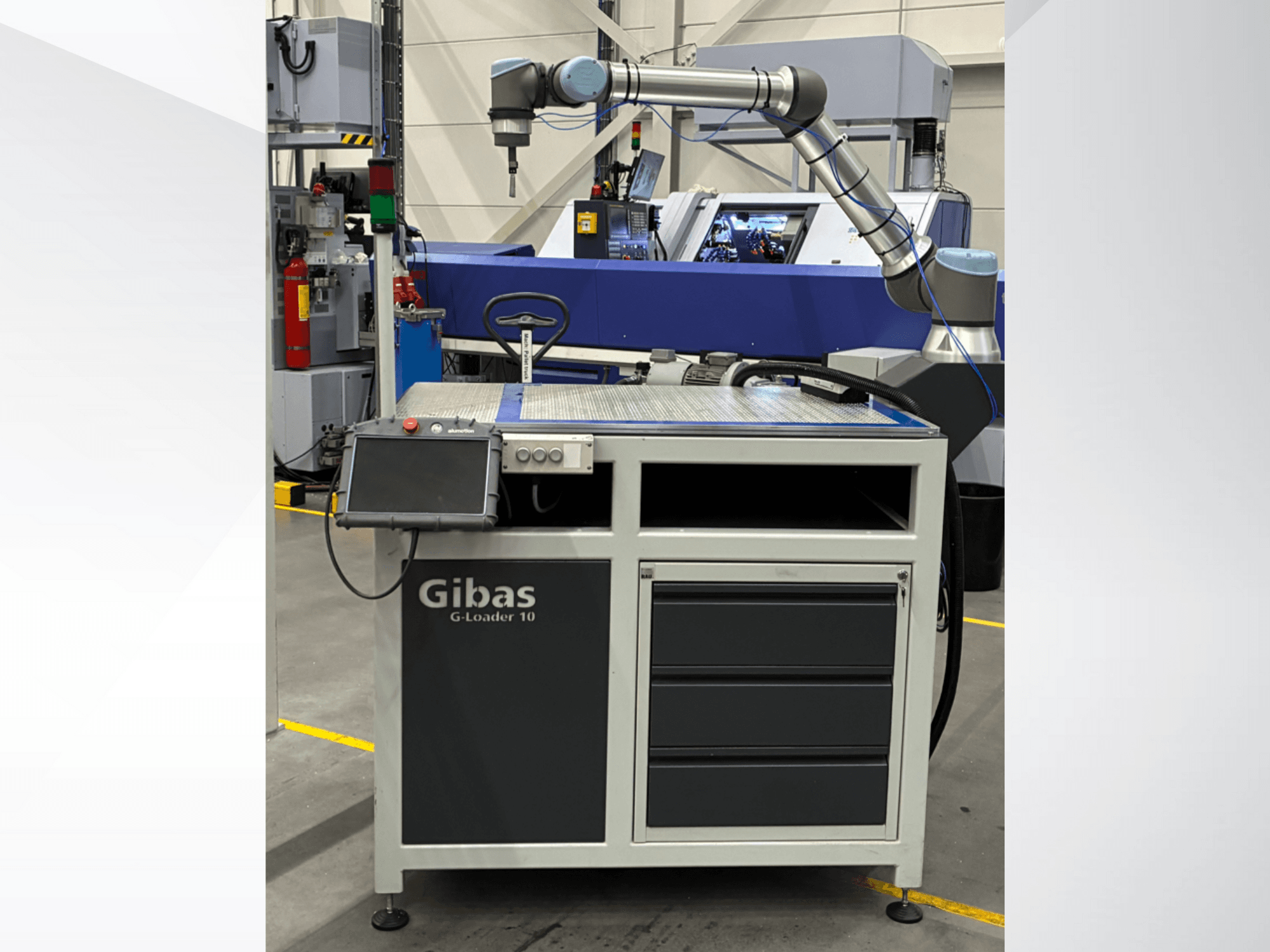 Gibas G-Loader 10 with robotic arm, front view; features touchscreen control and drawer storage in industrial setting.