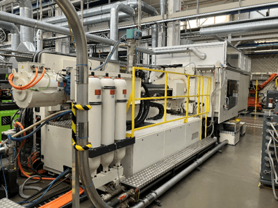 Industrial machine with white and gray casing, multiple hoses, and filter tanks; side view showcasing operational setup.