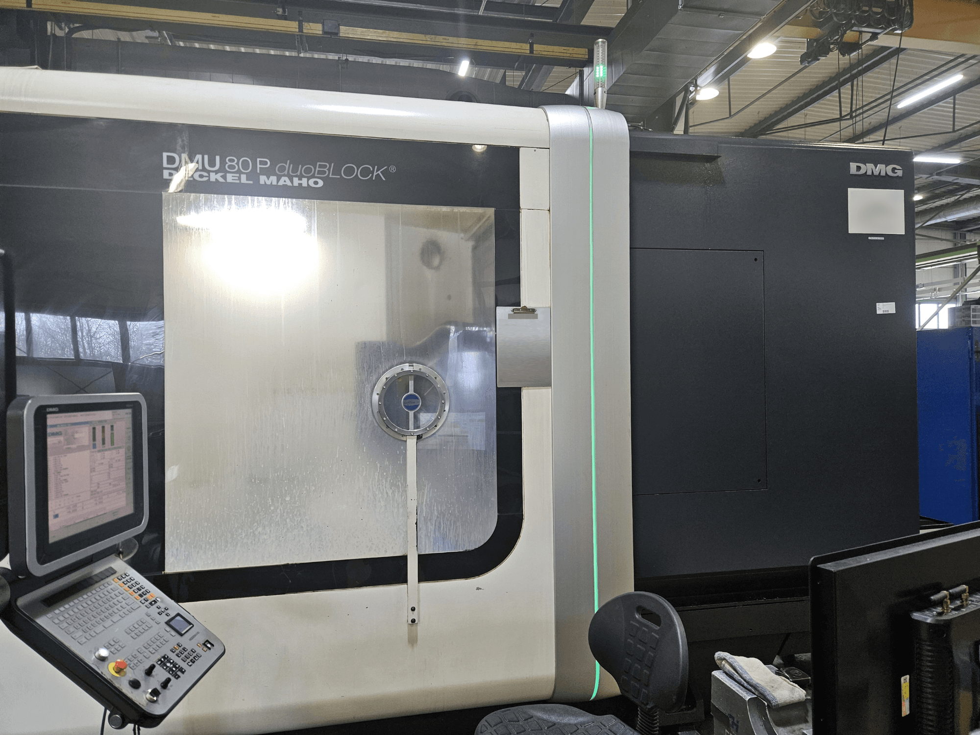 DMG DECKEL MAHO DMU 80P duoBLOCK vertical machining center, front view showcasing control panel and illuminated cutting area.
