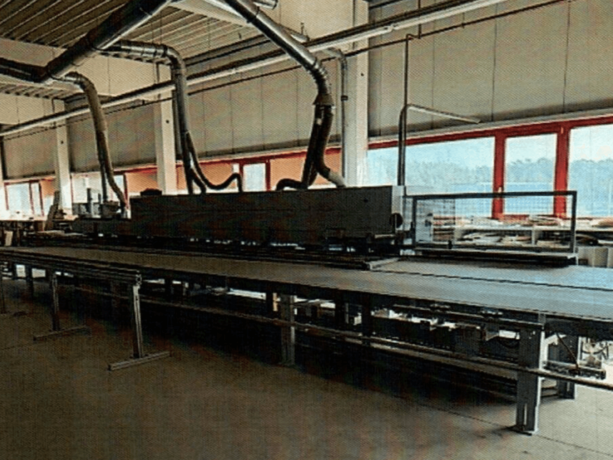 HOMAG KAL 370 edgebander in a workshop, side view, showcasing the long, flat worktable with ventilation ducts above.